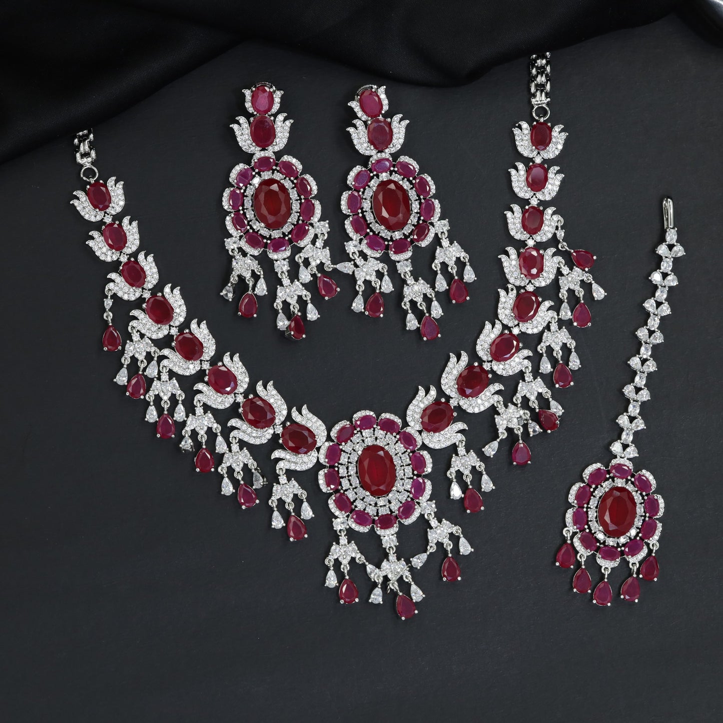 Traditional sweeping tulip motif rhodium necklace set with a central oval rosette drop