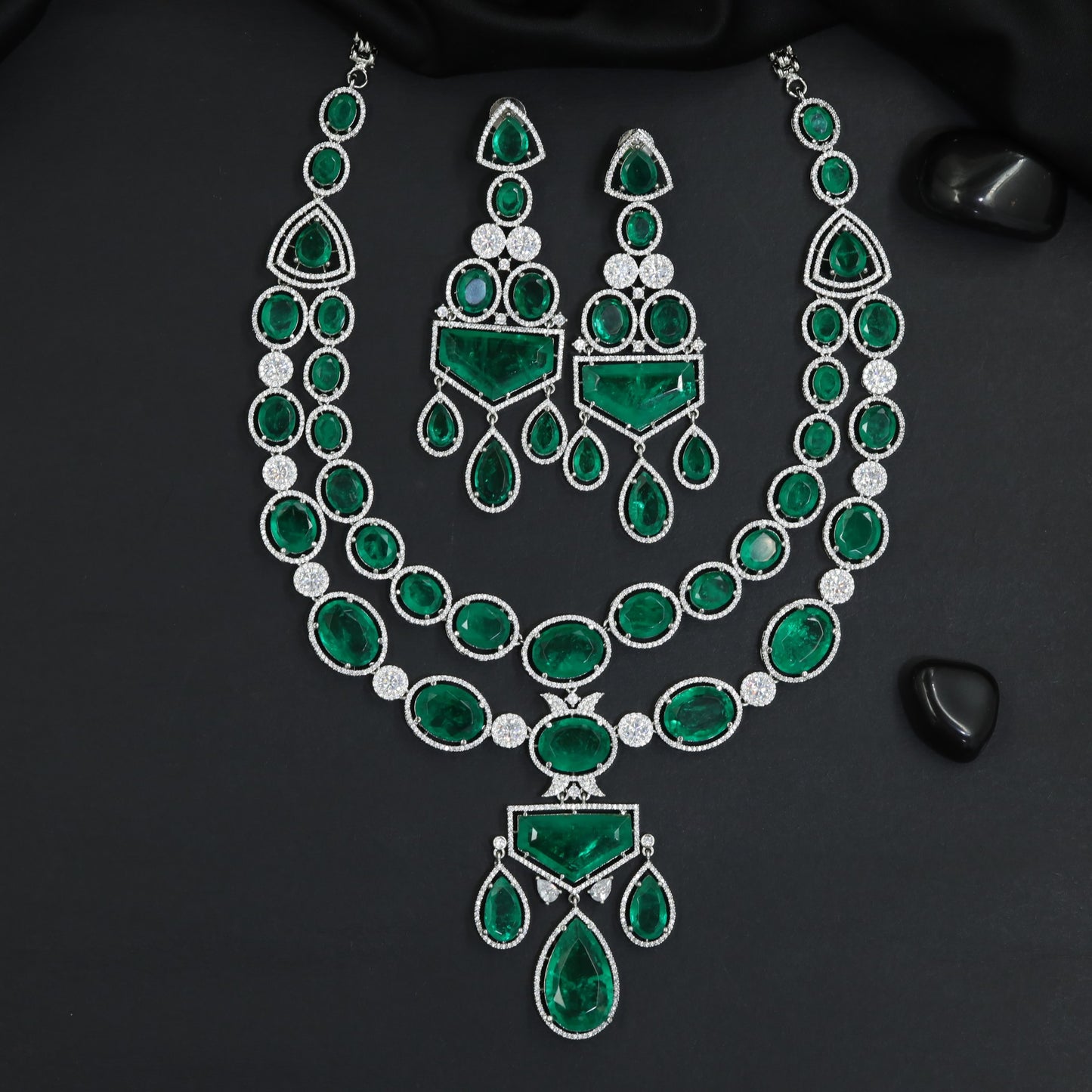 Fine polished multi-row oval strand rhodium long haara featuring a structural centerpiece