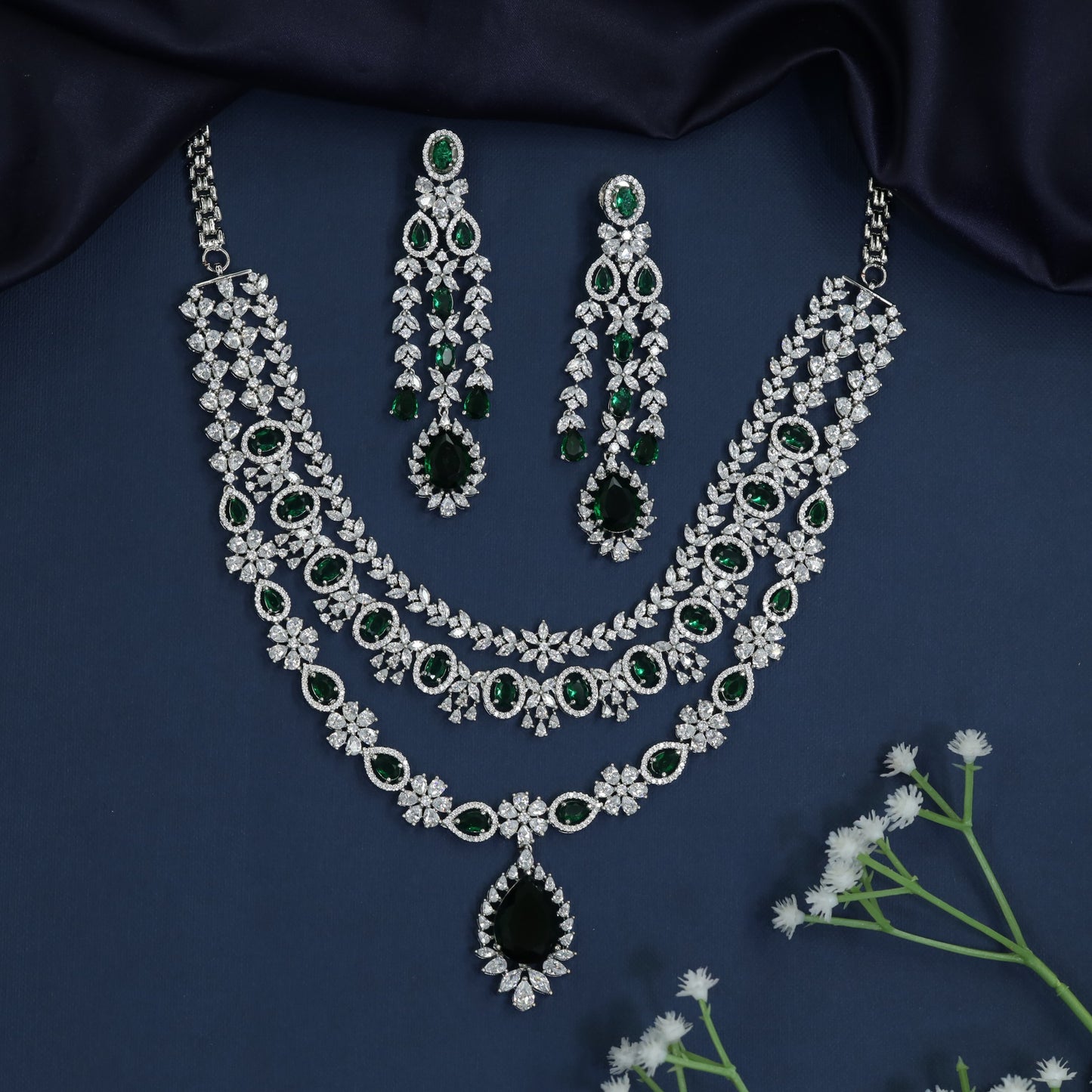 Rhodium necklace with pendant frame centerpiece and triple strand silhouette