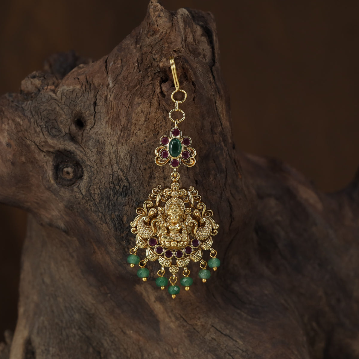 Antique Tikka showcasing a seated Lakshmi framed by graceful peacock figures