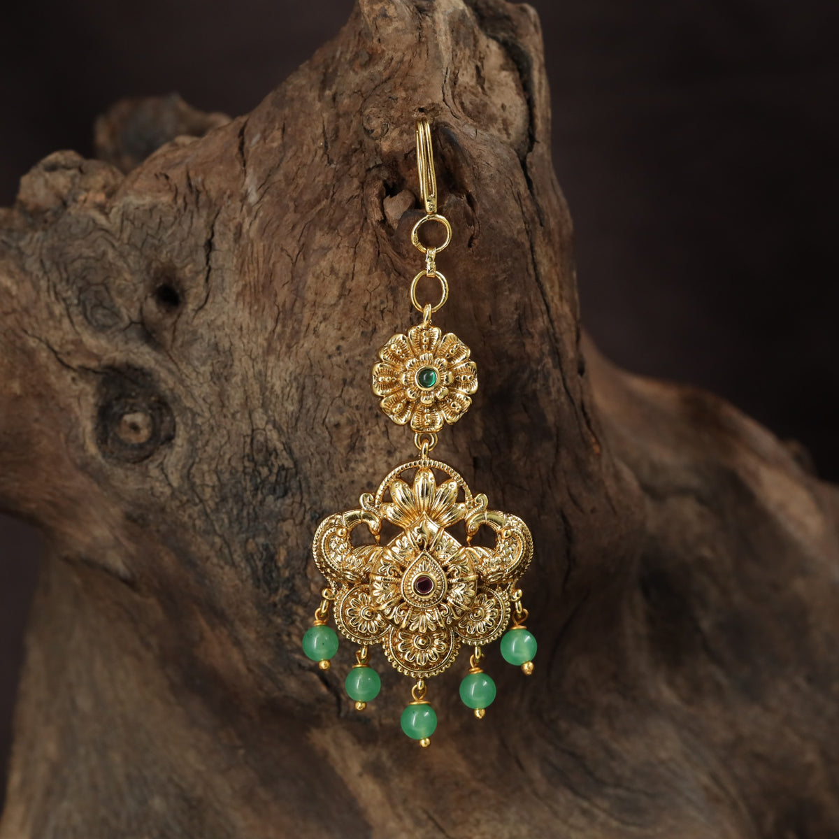 Regal peacock Tikka with ornate floral detailing and graceful hanging drops