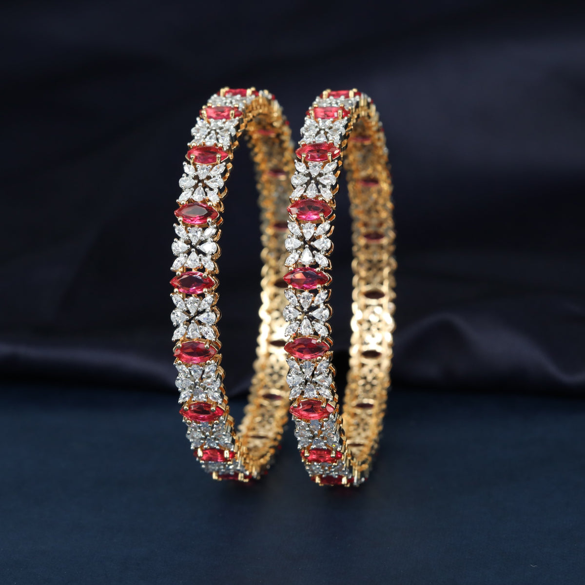 Gj Bangles designed with alternating oval elements and delicate flower shaped clusters
