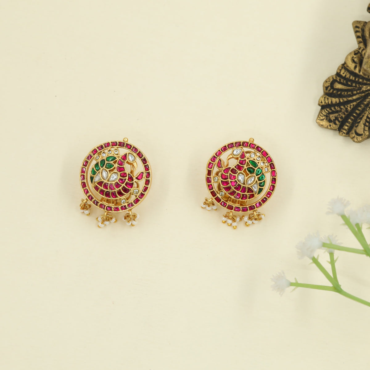 Ornate Jadau peacock studs with signature bead accents