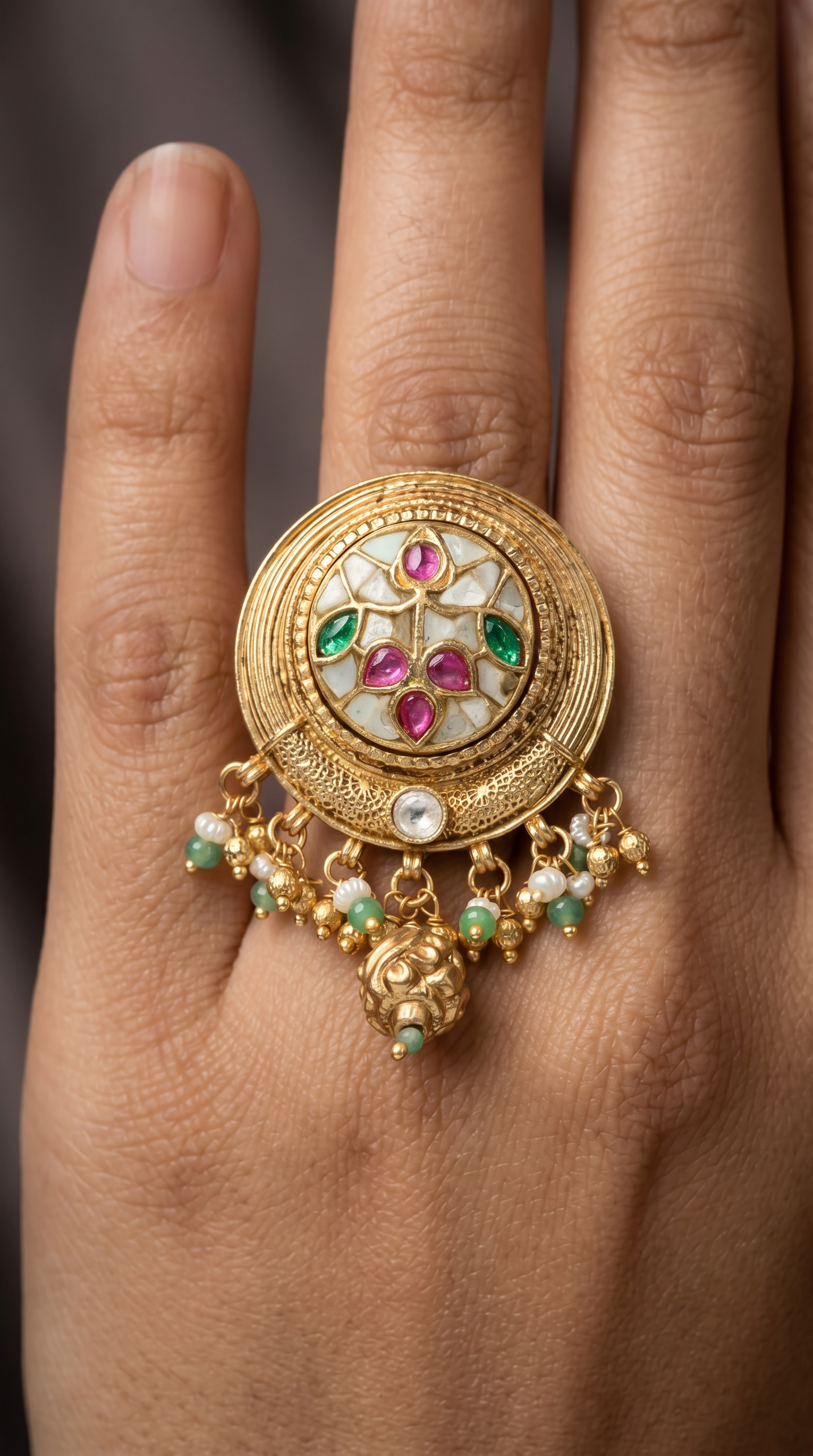 Circular disc kundan finger ring with carved radial layers and floral center cluster with drop fringe