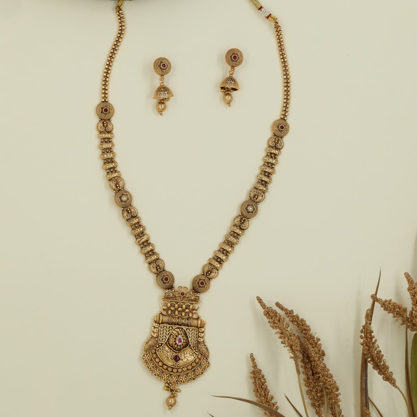 Intricate disc long haara with embossed links and wide drop pendant with central accent