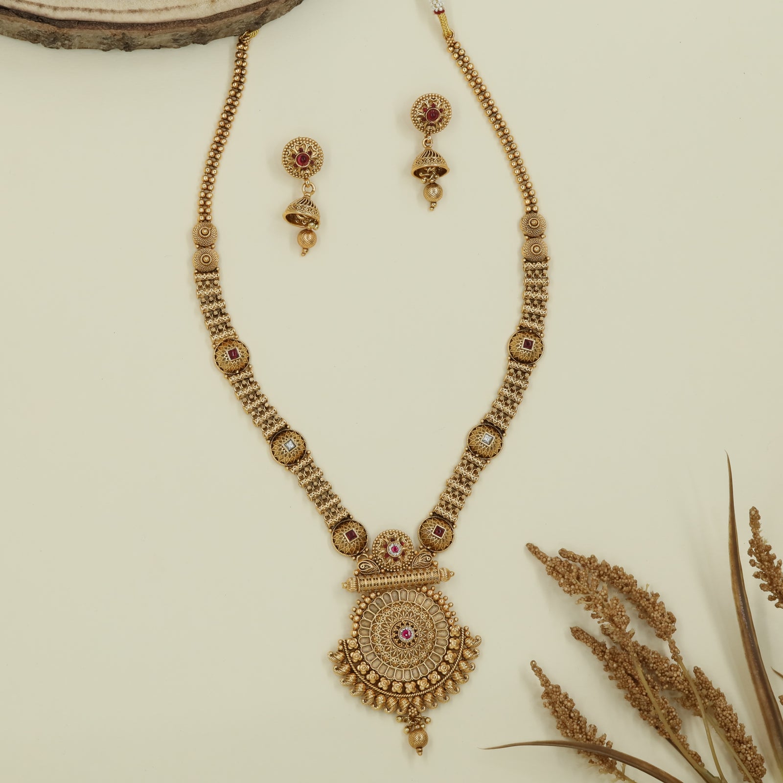 Embossed disc long haara with carved round connectors and layered circular pendant with drop