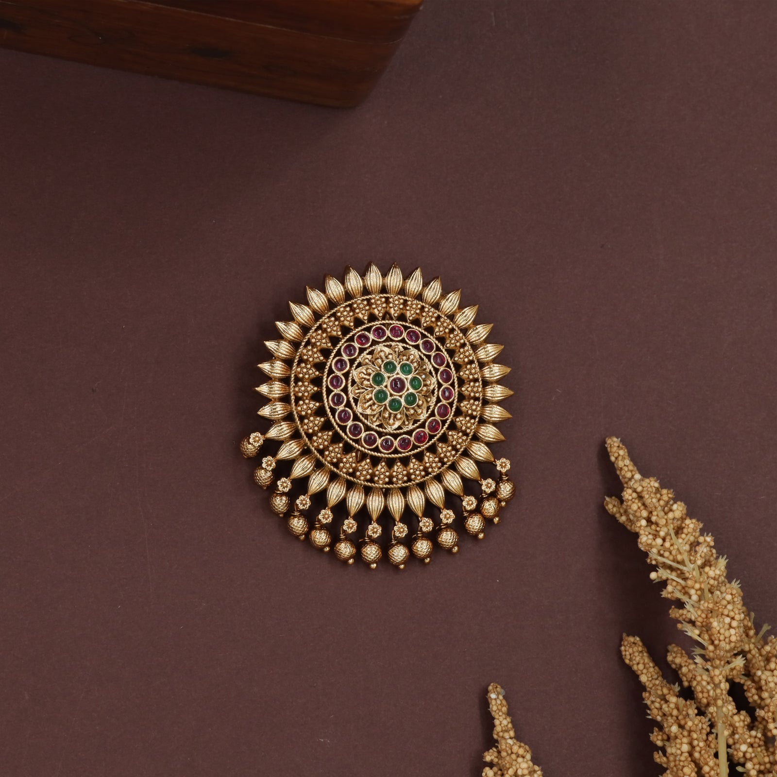 Sunburst round jade bille with petal edged frame and hanging bead clusters