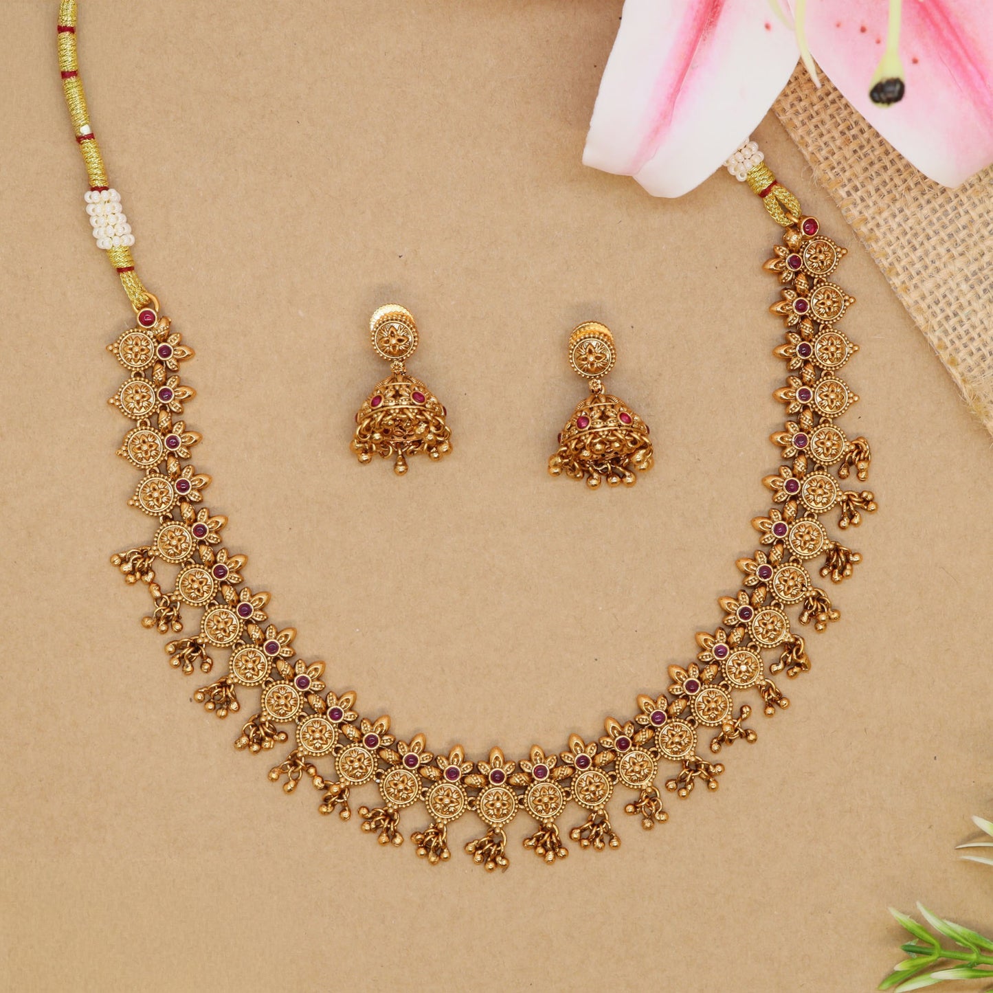 Floral link necklace with repeating round panels and small drop hangings