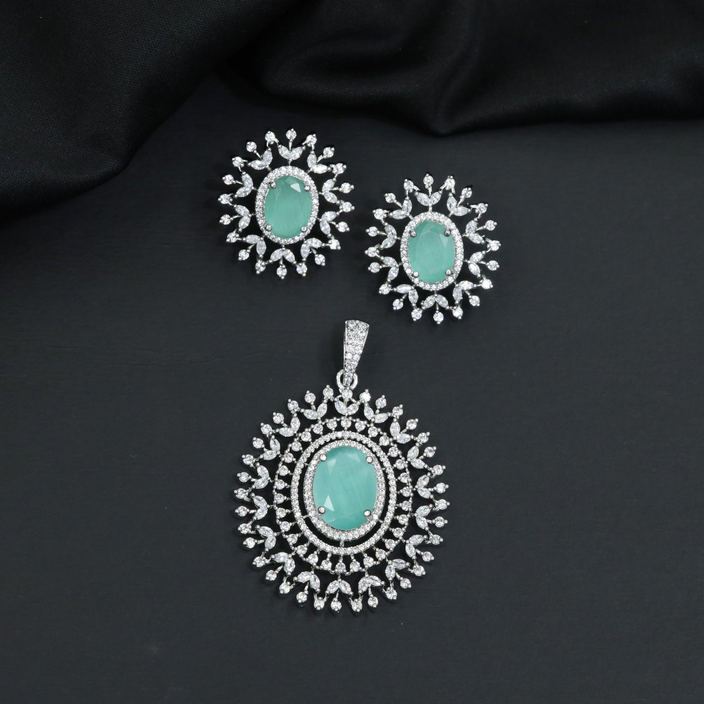 Rhodium finish pendant set with oval drop and radiant border design