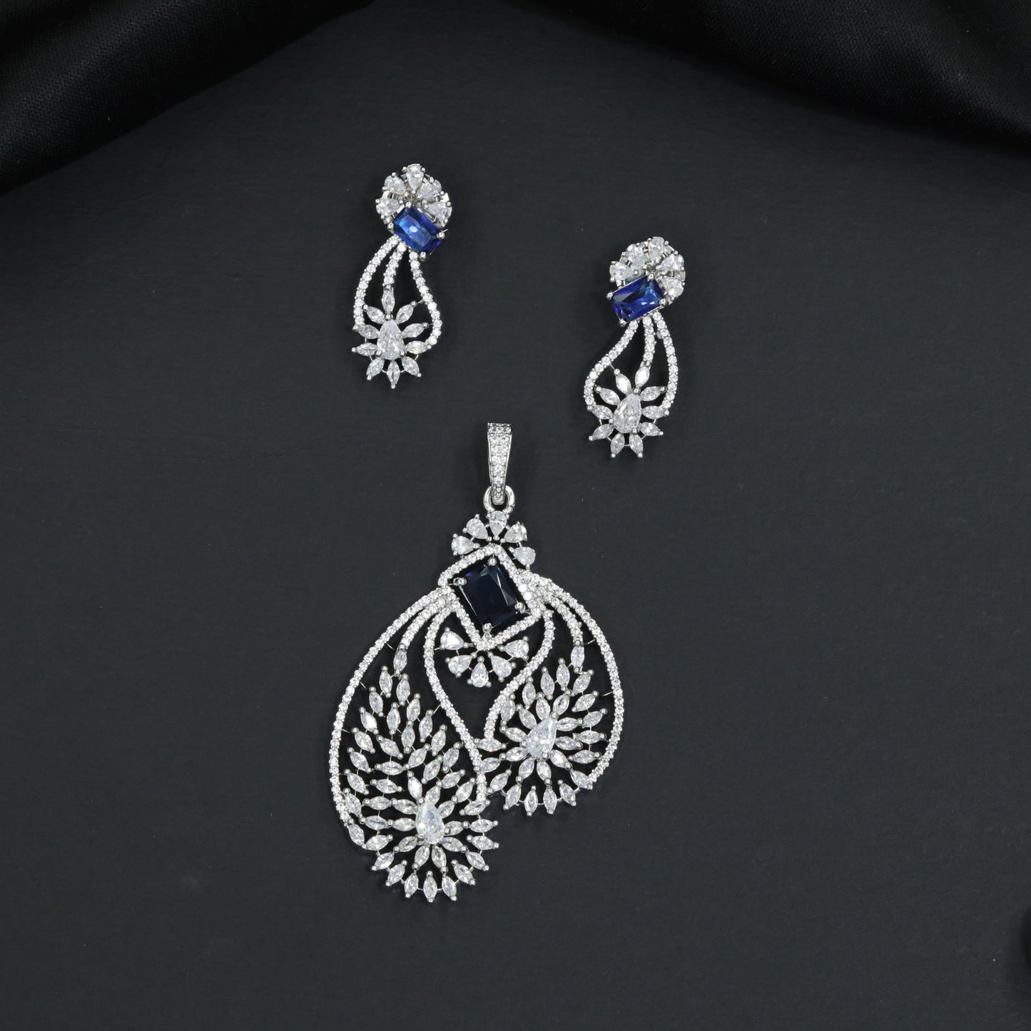 Artistic floral pendant set featuring twin leaf silhouettes and layered flower clusters