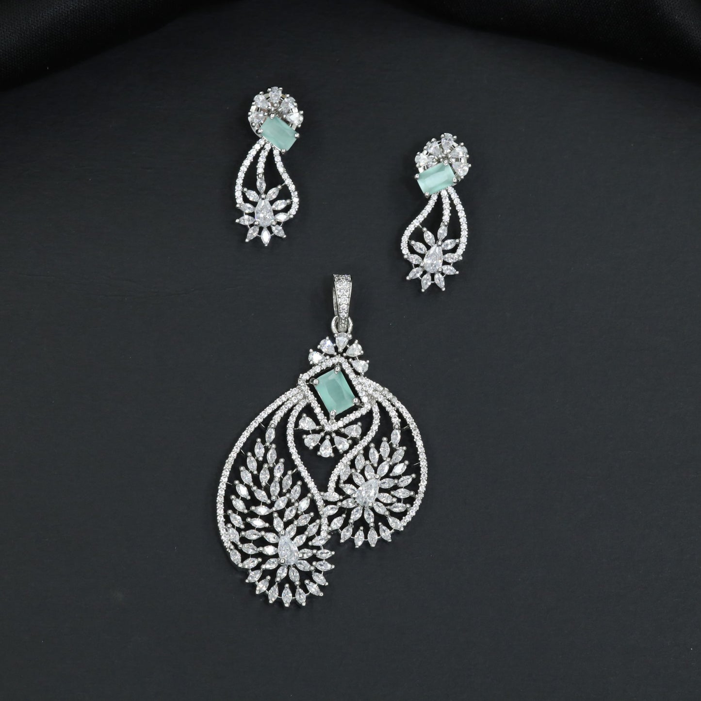 Artistic floral pendant set featuring twin leaf silhouettes and layered flower clusters