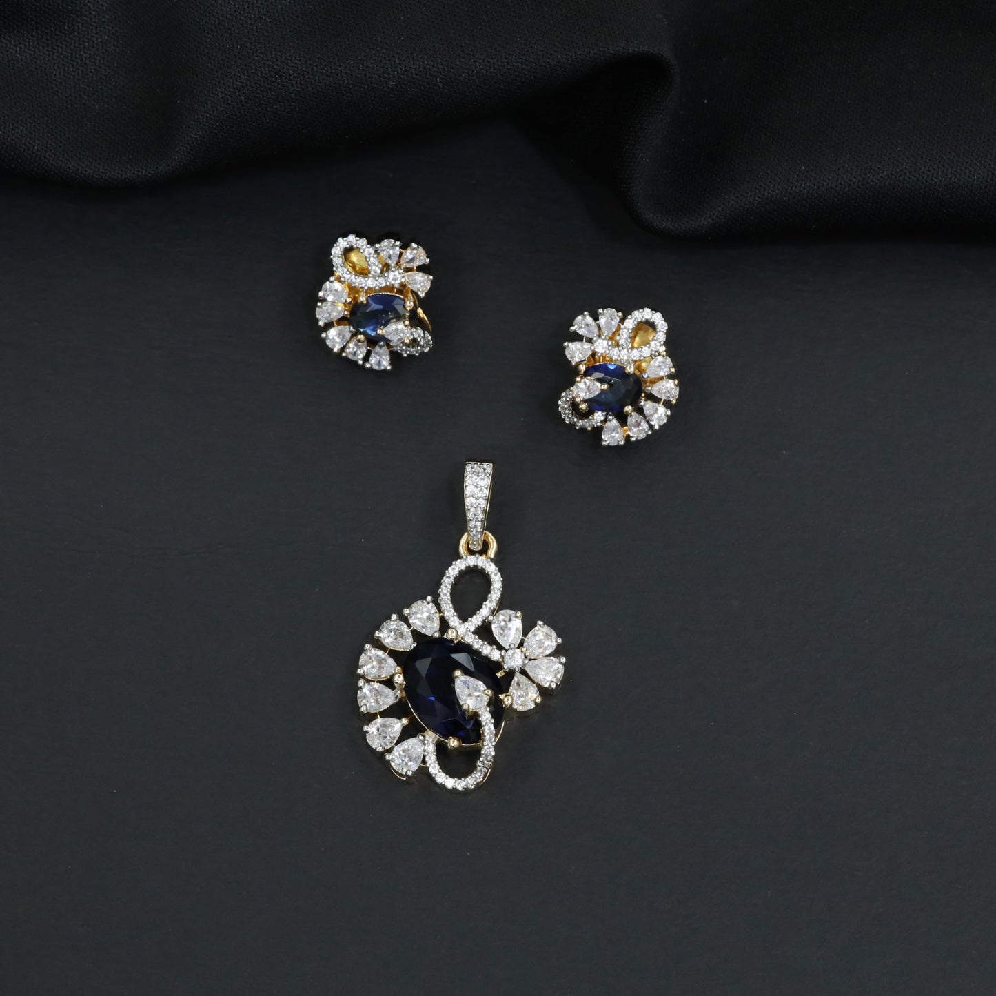 Floral swirl pendant set with leaf cluster detailing and matching stud earrings