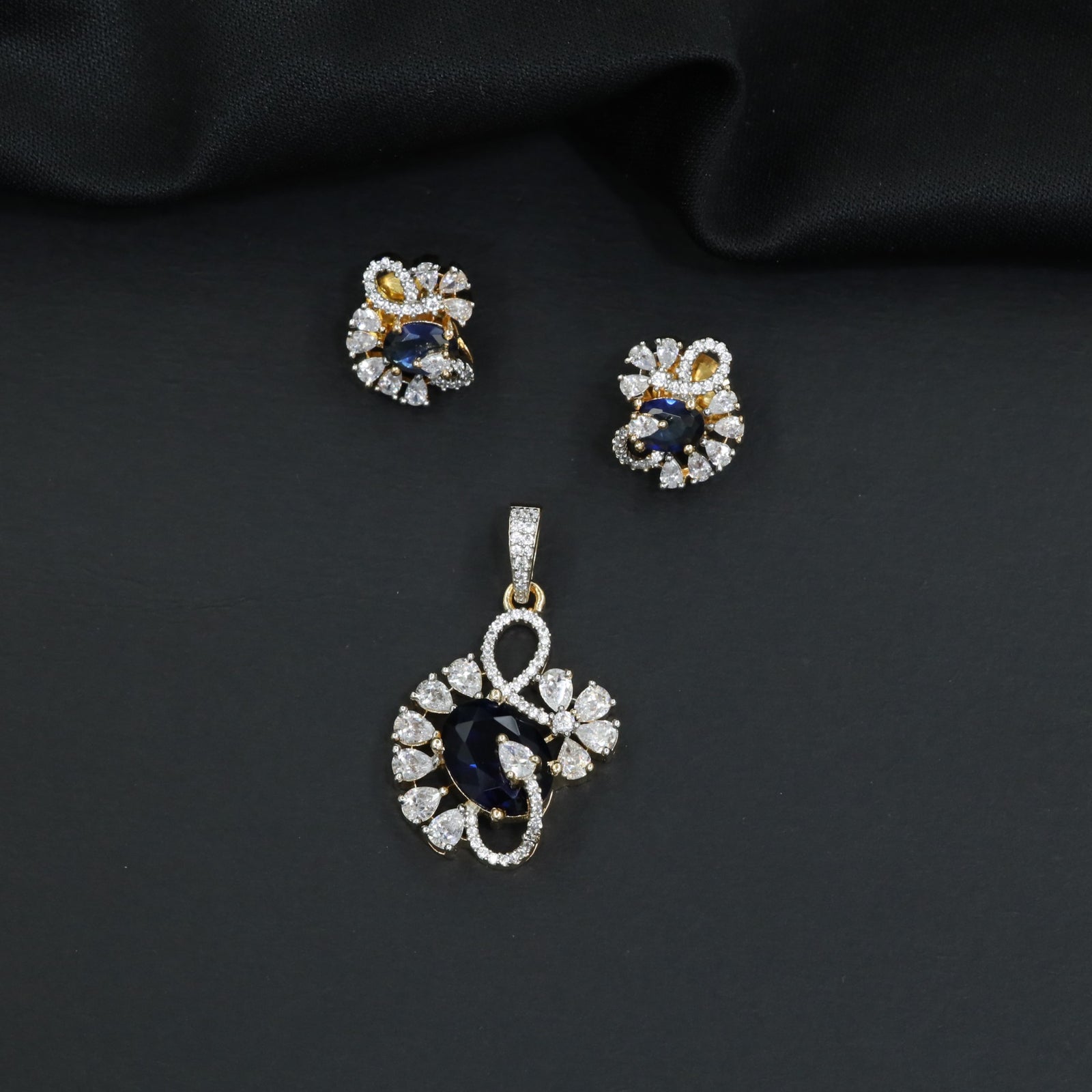 Floral swirl pendant set with leaf cluster detailing and matching stud earrings