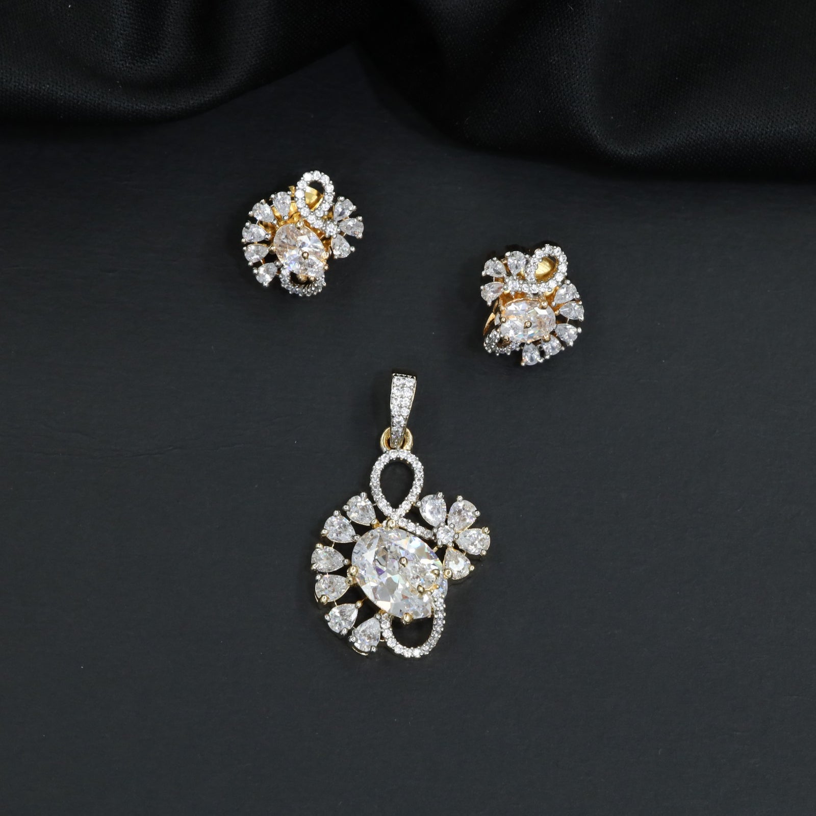 Floral swirl pendant set with leaf cluster detailing and matching stud earrings
