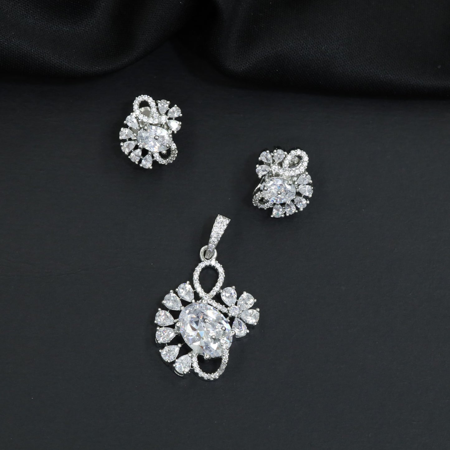 Floral swirl pendant set with leaf cluster detailing and matching stud earrings