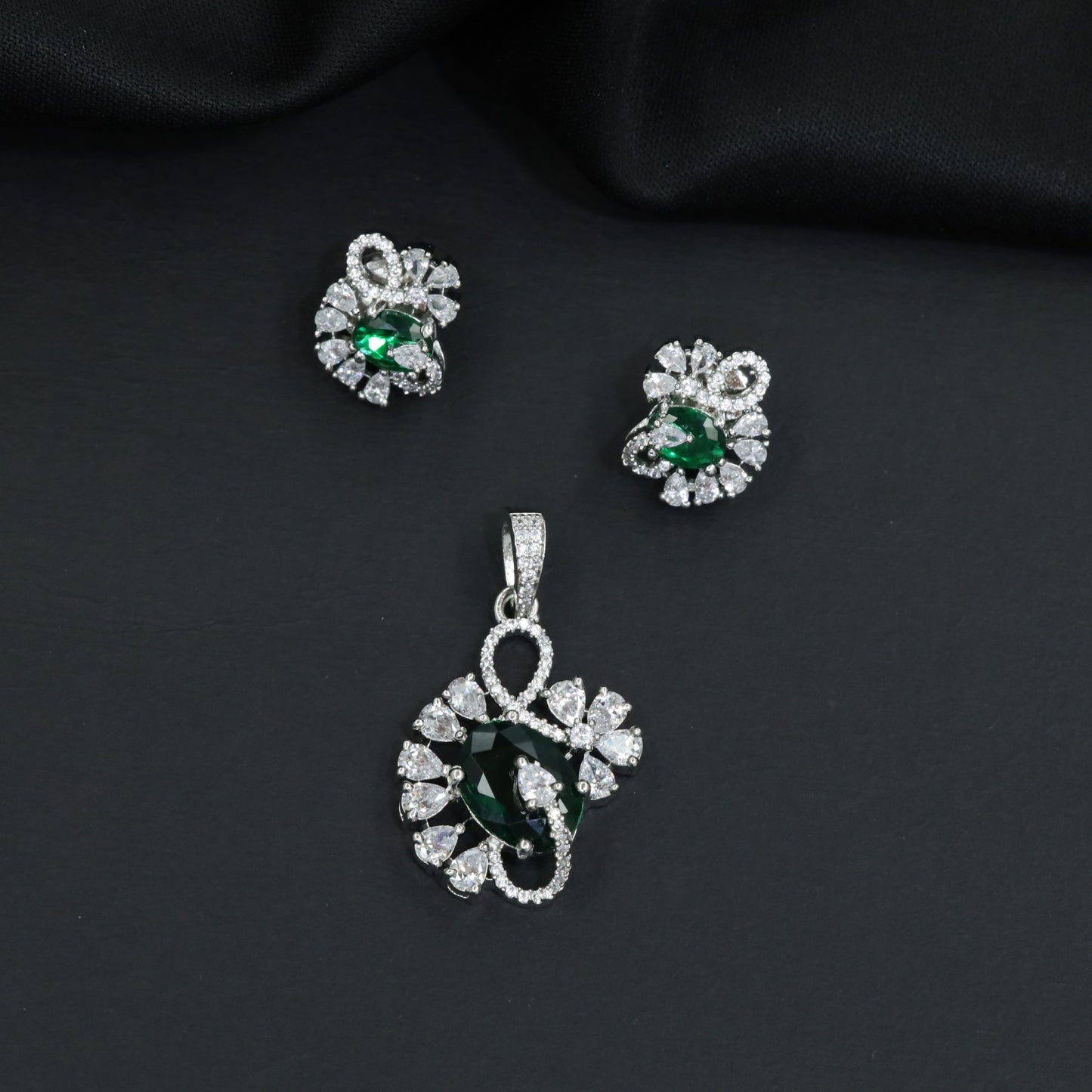 Floral swirl pendant set with leaf cluster detailing and matching stud earrings