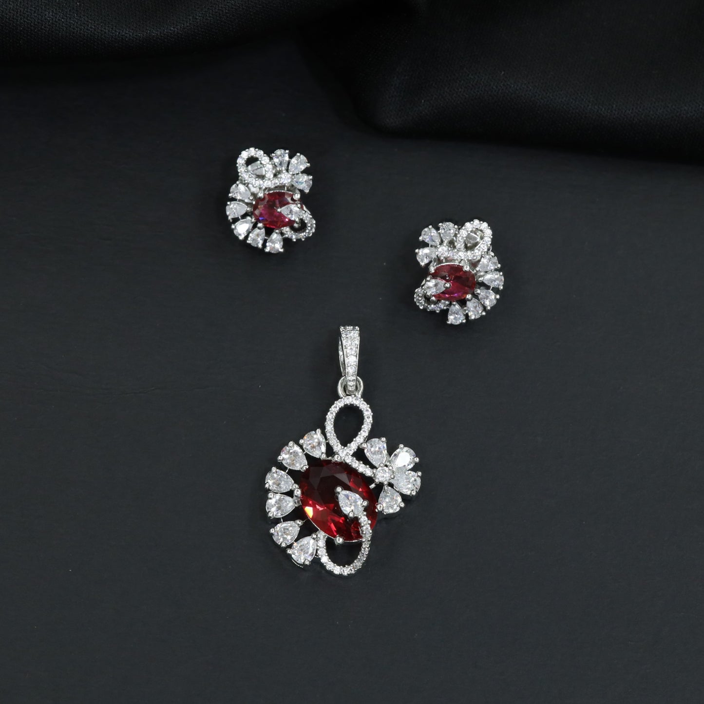 Floral swirl pendant set with leaf cluster detailing and matching stud earrings