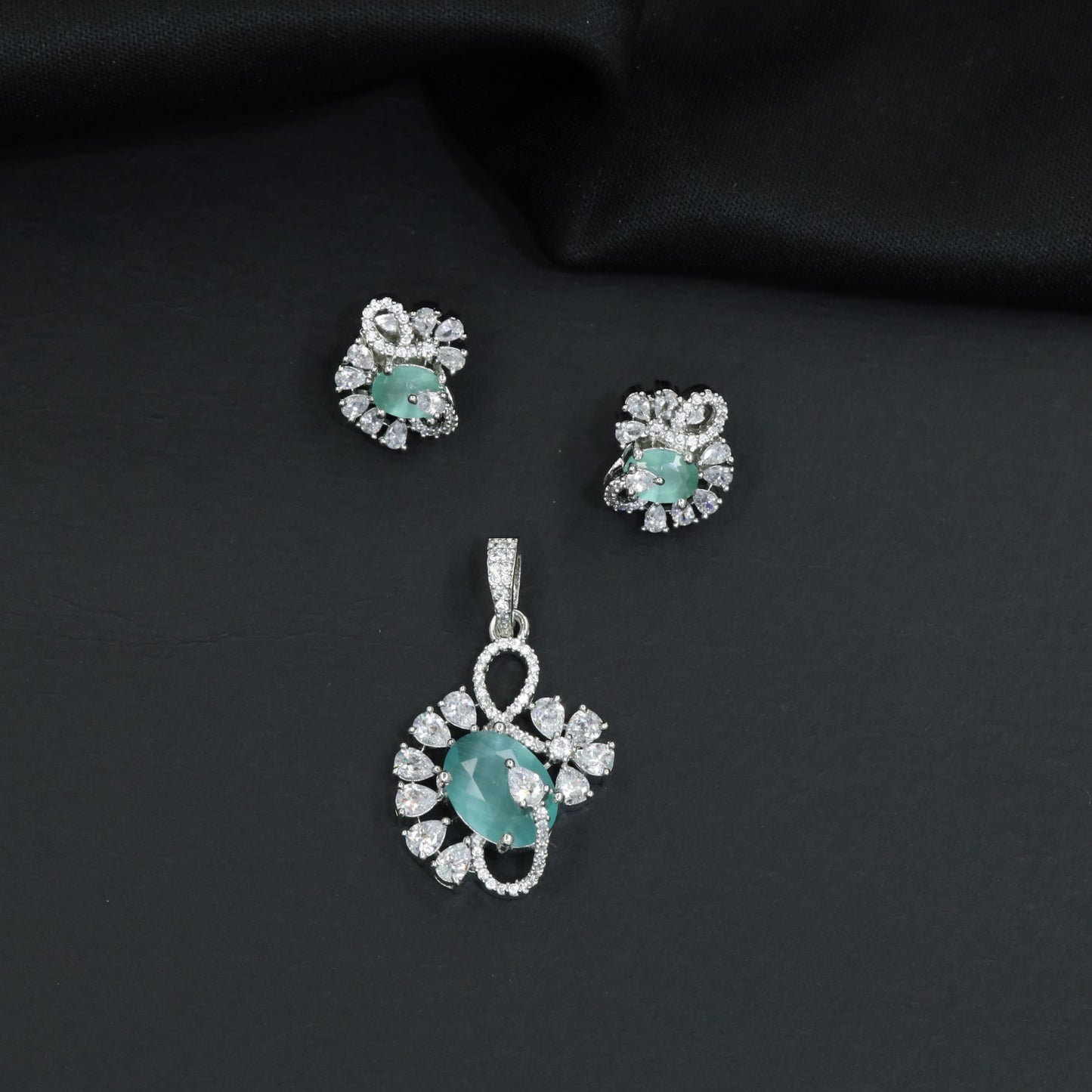 Floral swirl pendant set with leaf cluster detailing and matching stud earrings