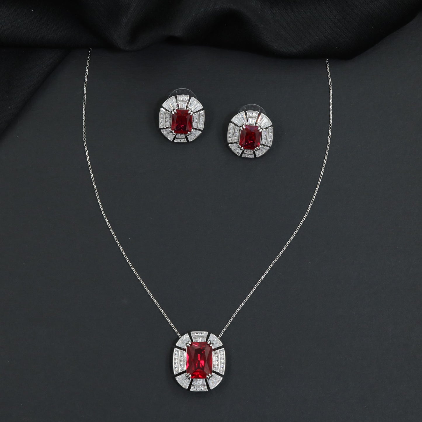 Contemporary pendant chain set with a structured medallion profile and matching stud earrings
