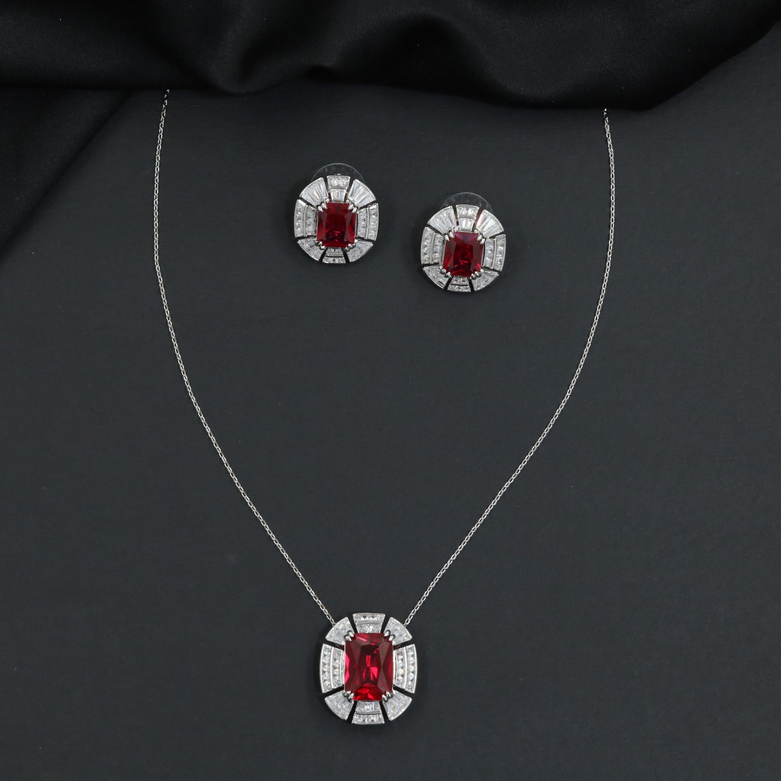 Contemporary pendant chain set with a structured medallion profile and matching stud earrings