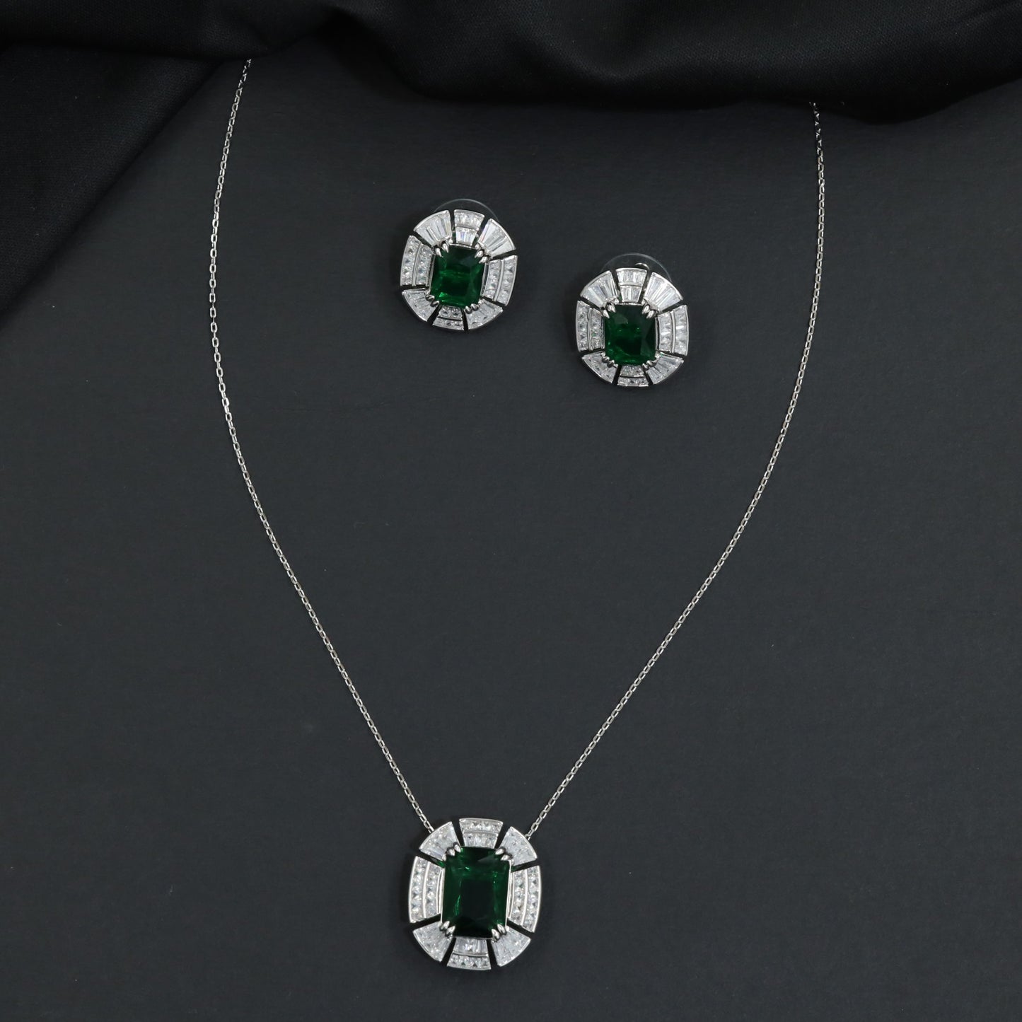Contemporary pendant chain set with a structured medallion profile and matching stud earrings