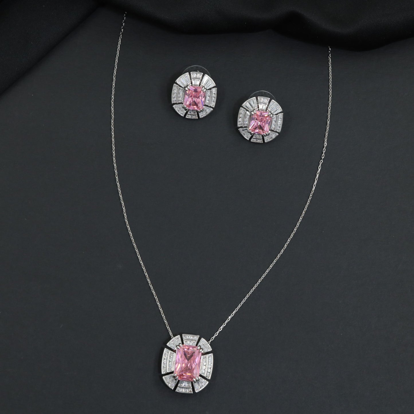 Contemporary pendant chain set with a structured medallion profile and matching stud earrings