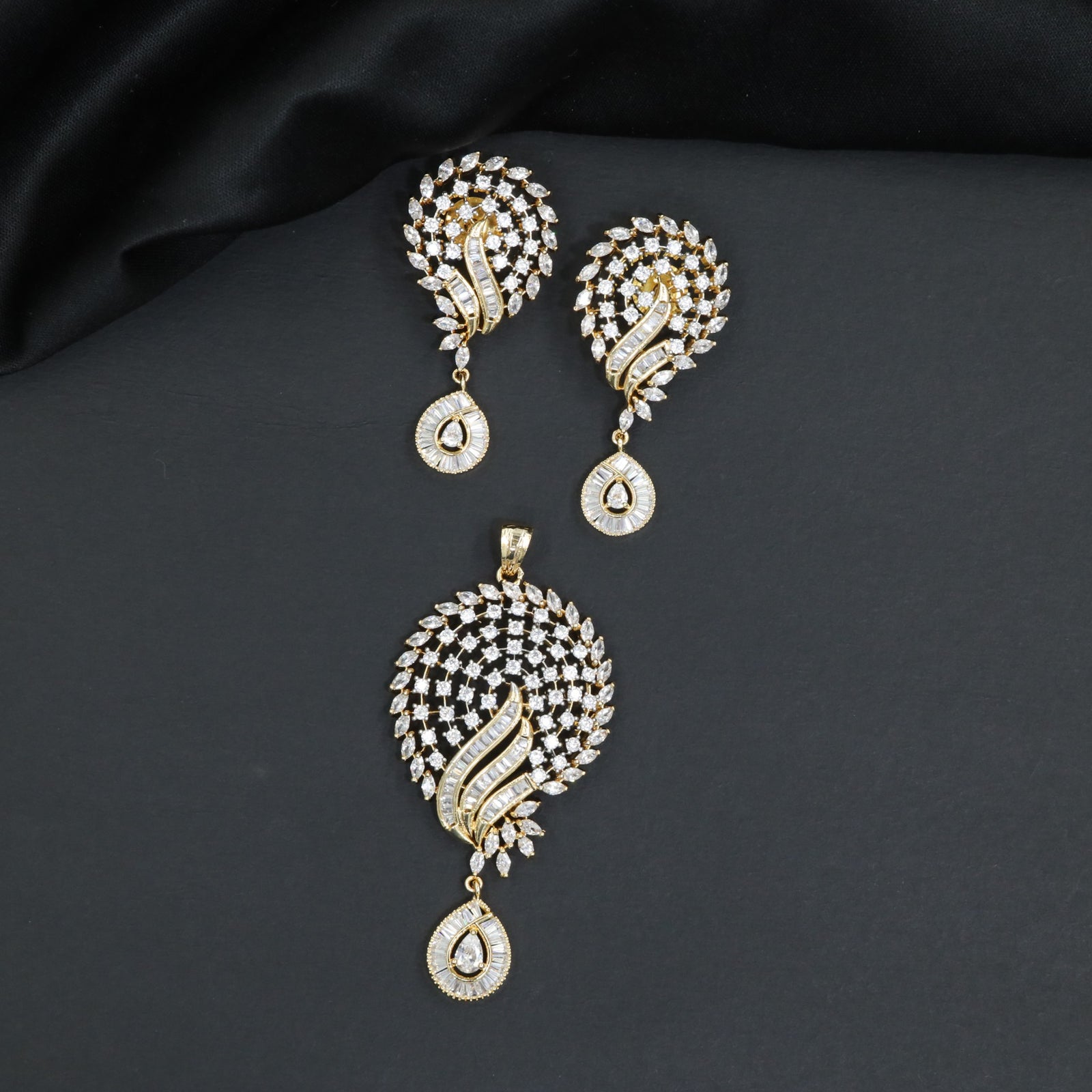 Graceful openwork round crest pendant set with stone accented teardrop dangles