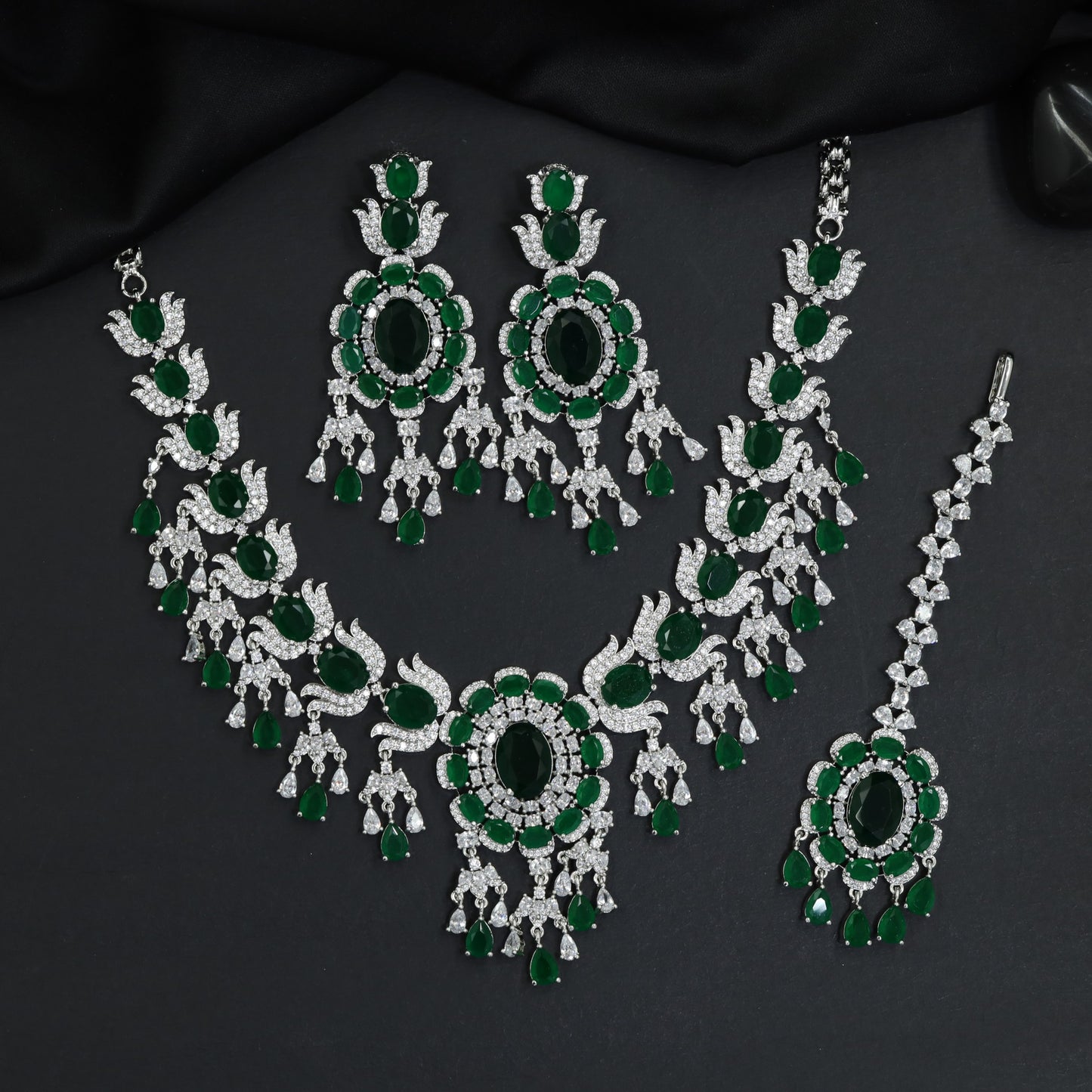 Traditional sweeping tulip motif rhodium necklace set with a central oval rosette drop