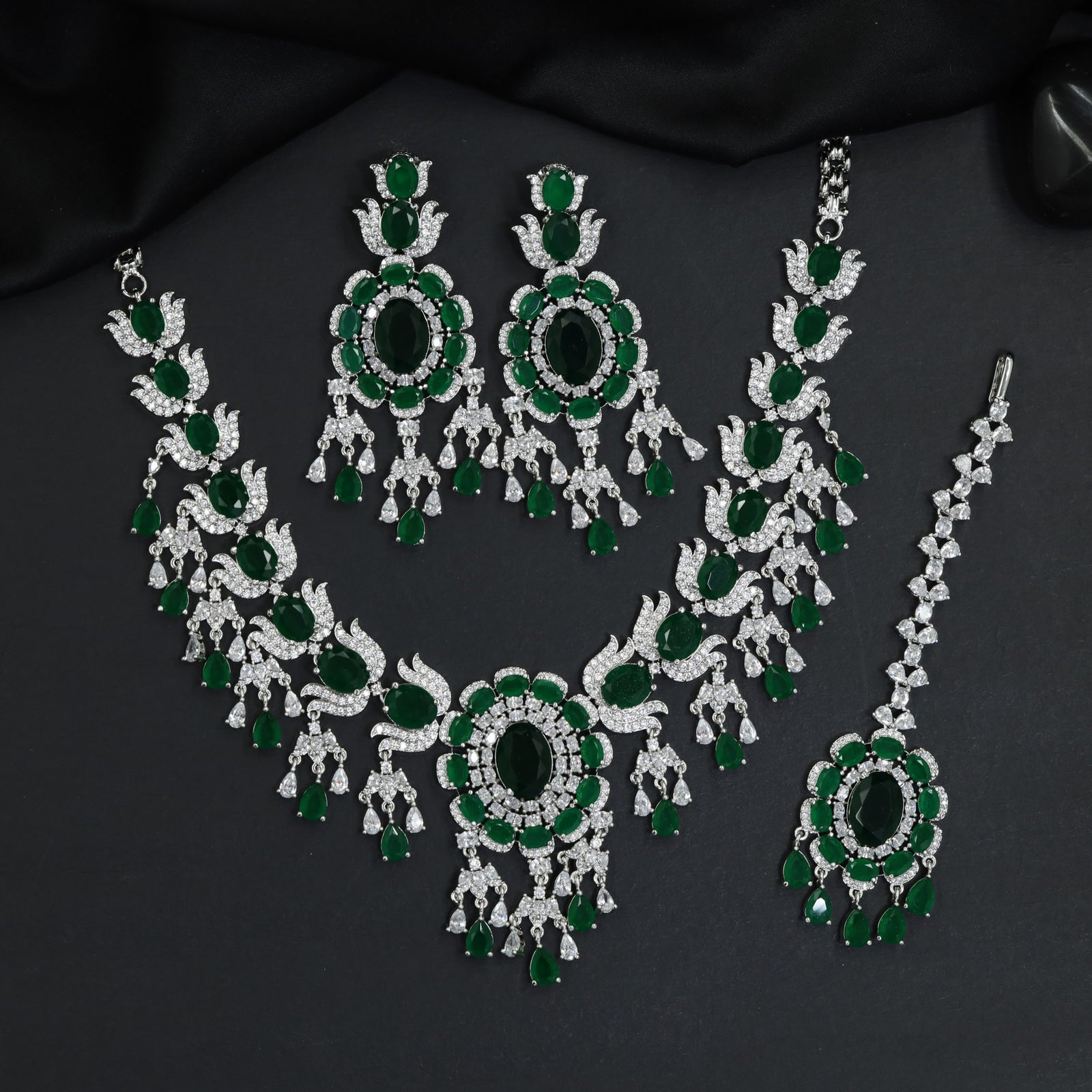 Traditional sweeping tulip motif rhodium necklace set with a central oval rosette drop
