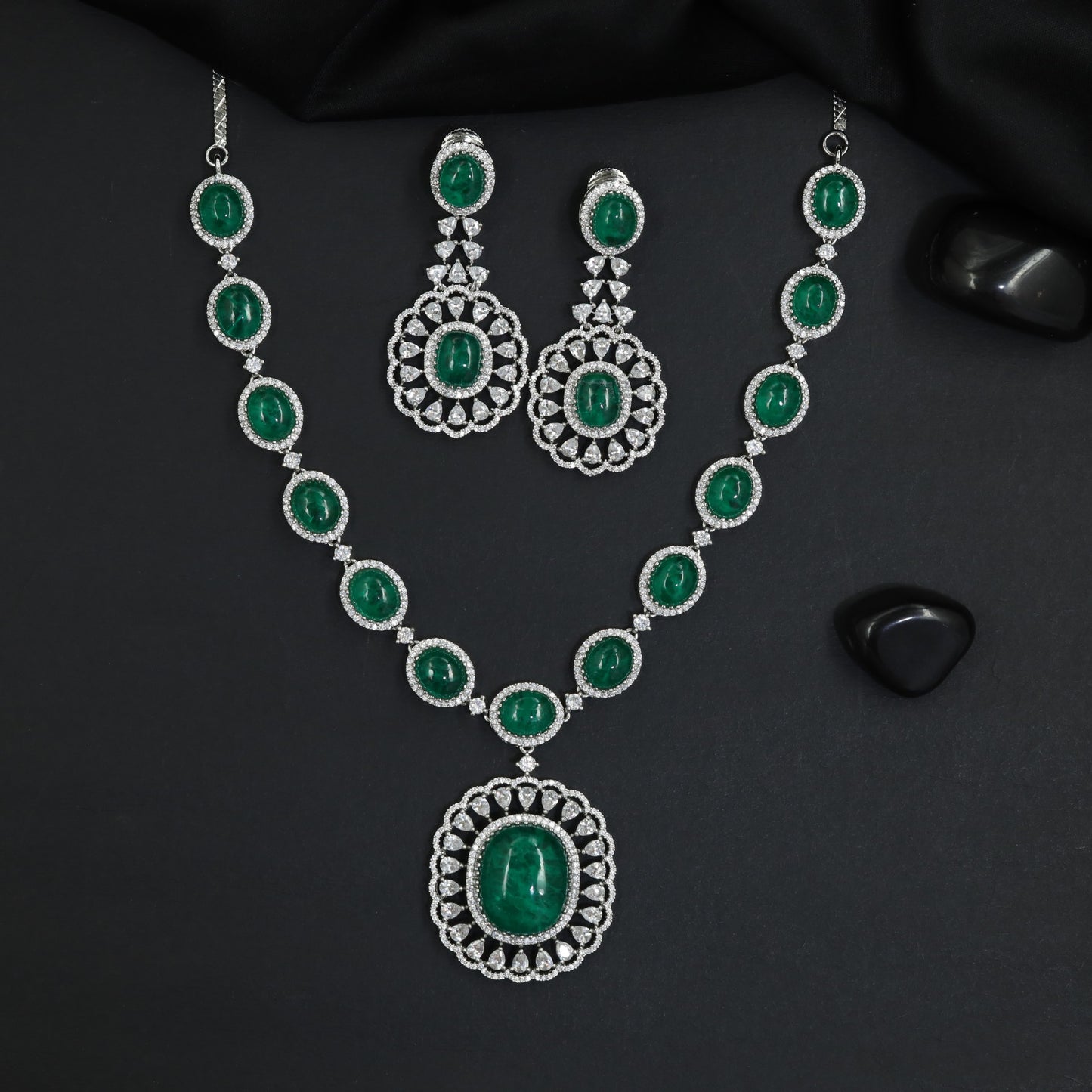 Shimmering uniform oval chain rhodium long haara with a central rosette medallion