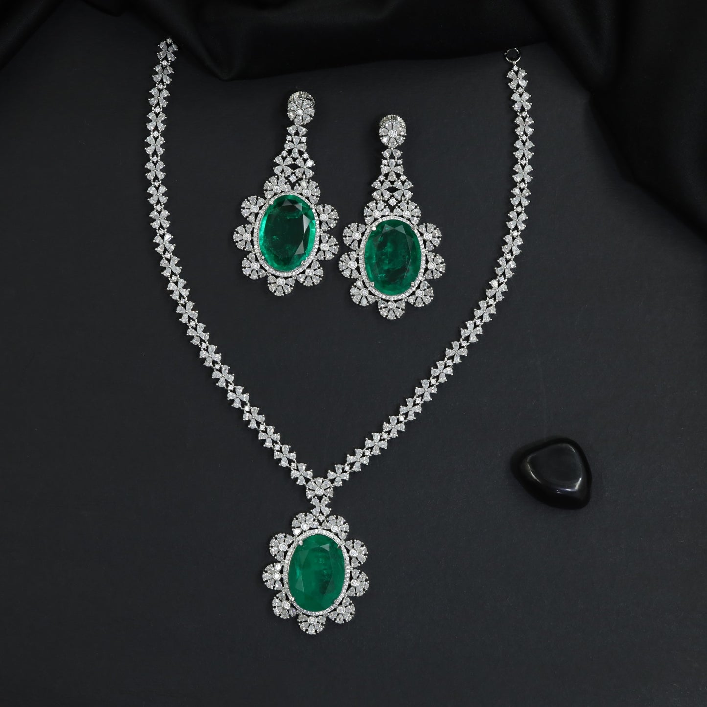 Shimmering uniform blossom chain rhodium long haara with a central rosette medallion