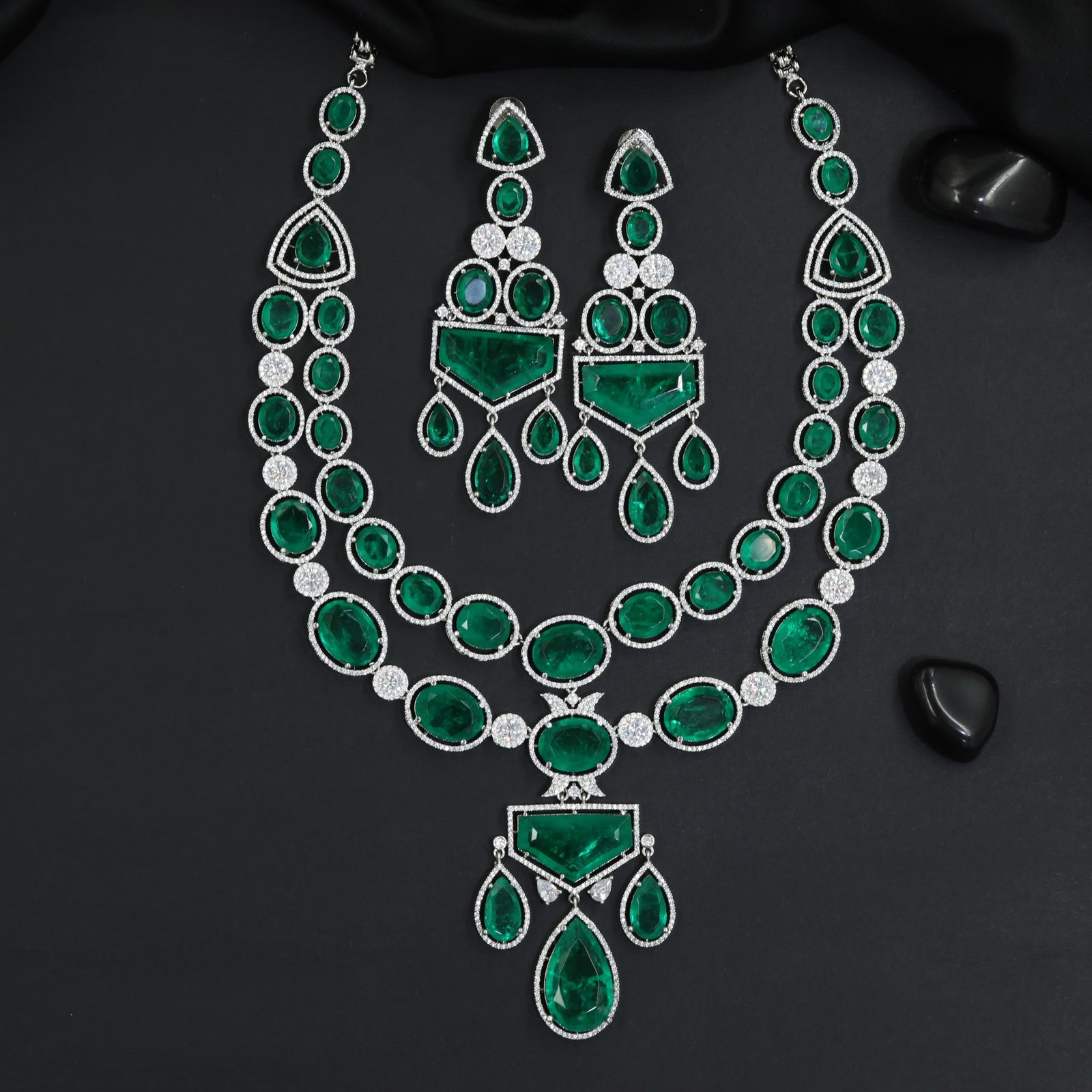 Fine polished multi-row oval strand rhodium long haara featuring a structural centerpiece