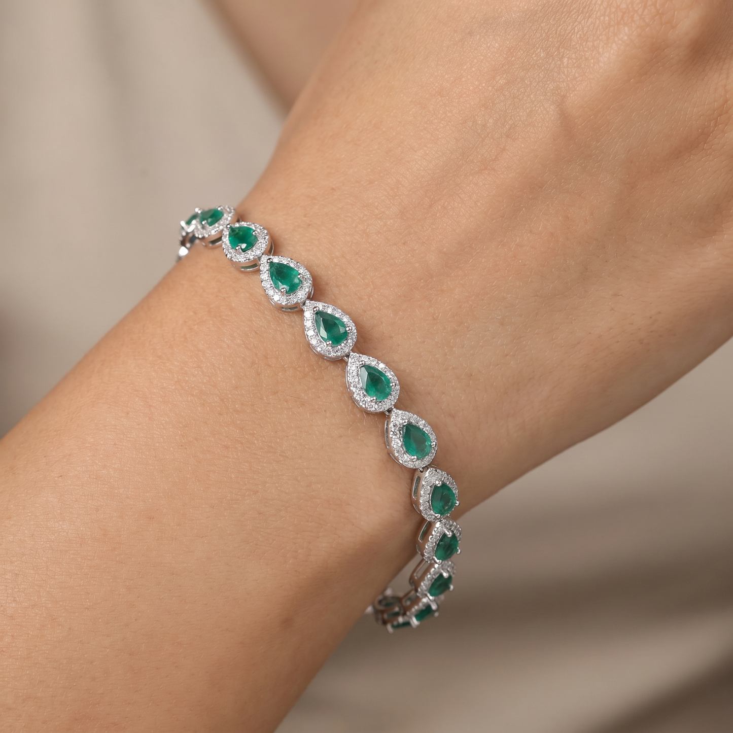 Iconic rhodium bracelet featuring gemstone crest accents