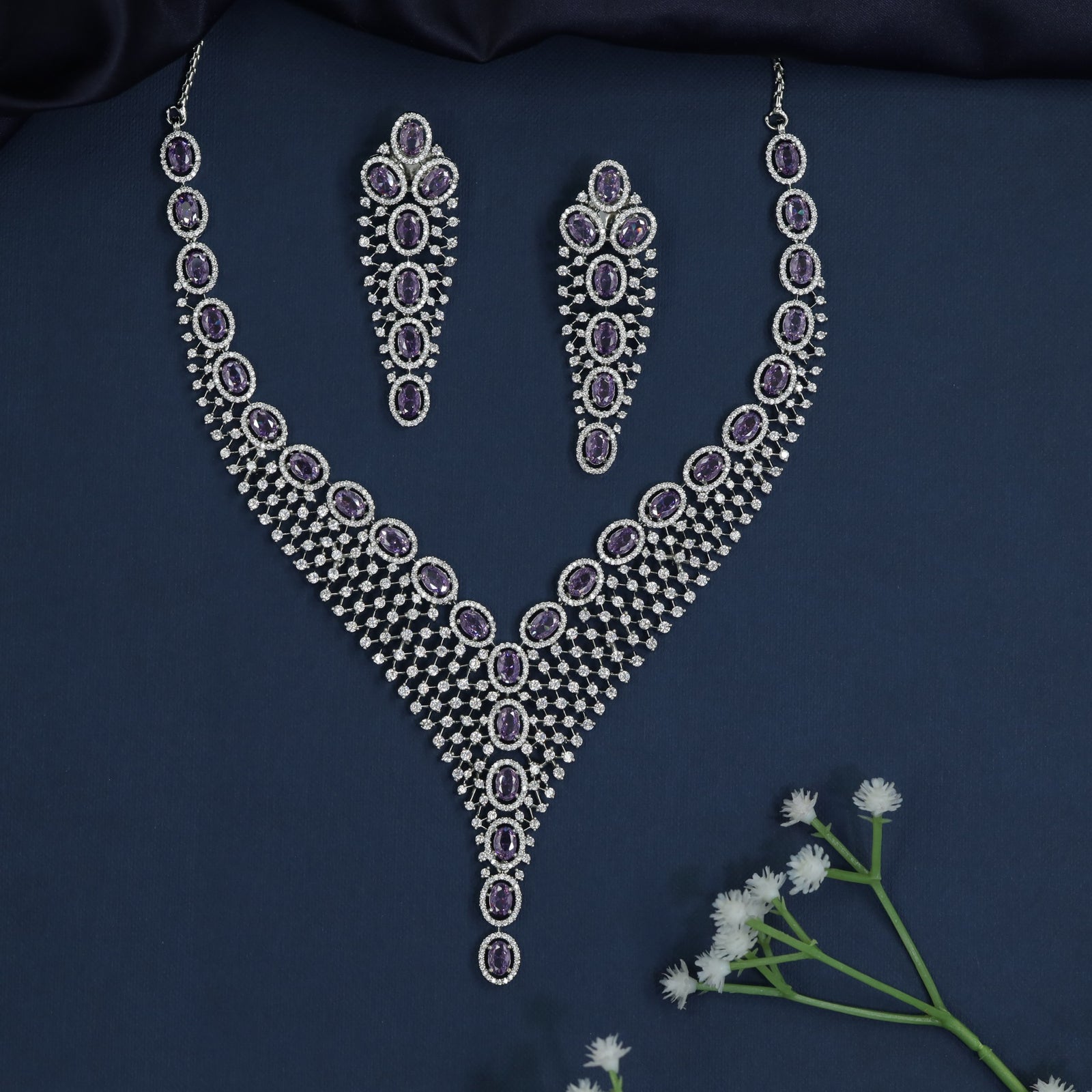 Rhodium necklace with graduated rosette arrangement and pendant drop