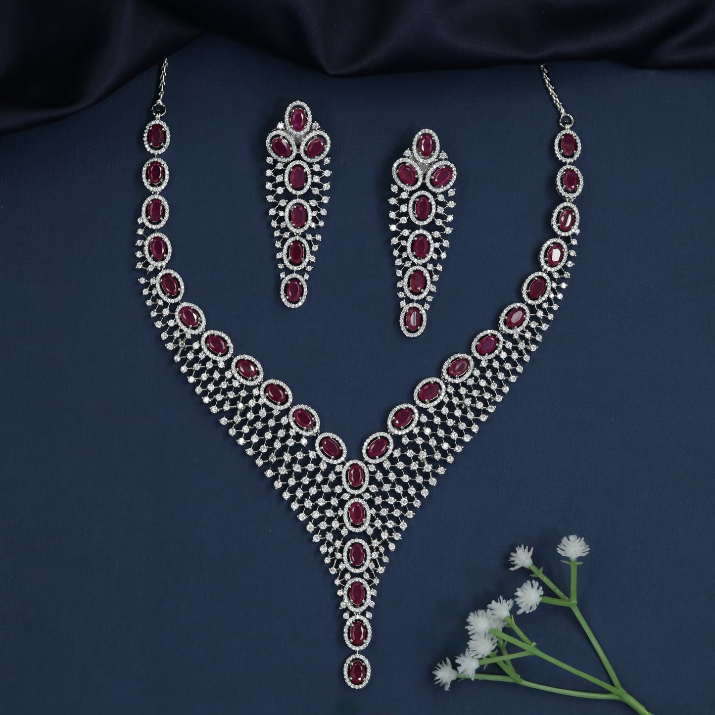 Rhodium necklace with graduated rosette arrangement and pendant drop