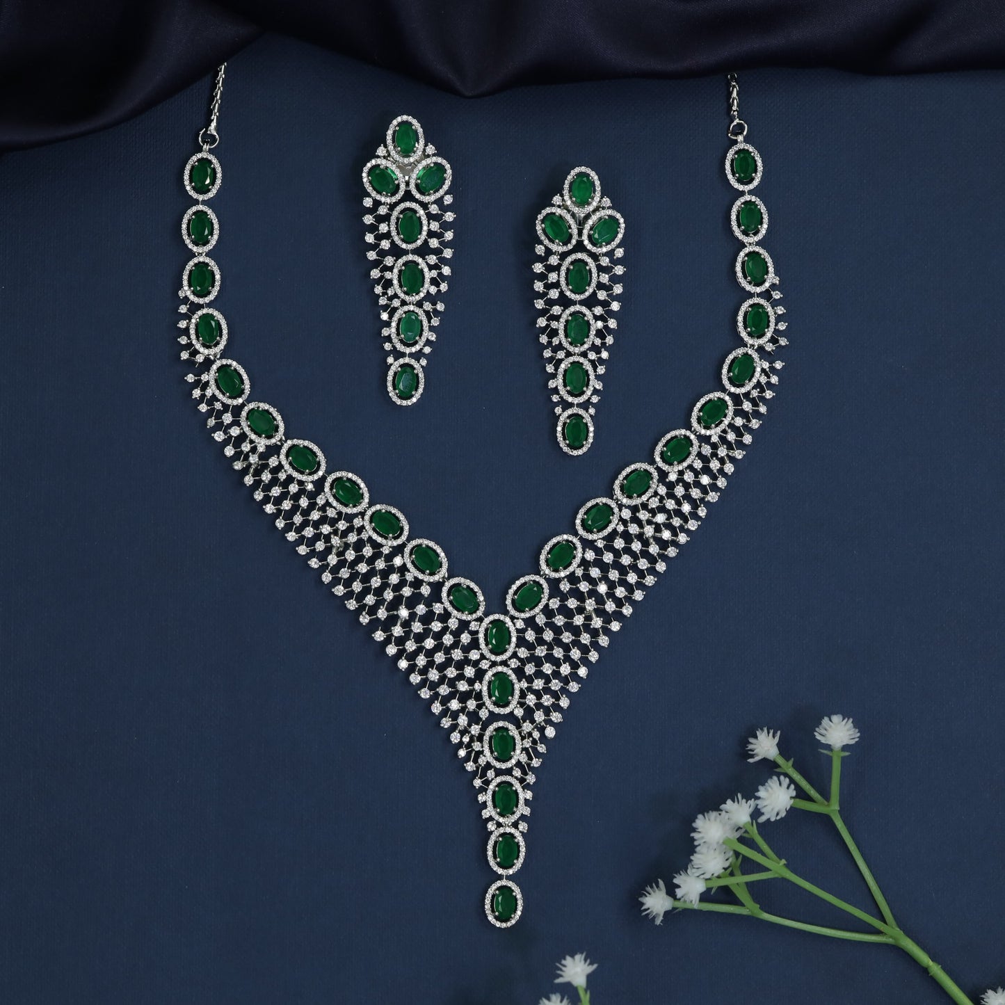 Rhodium necklace with graduated rosette arrangement and pendant drop