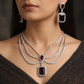 Rhodium Necklace Featuring Geometric Pendants and Triple Strand Construction