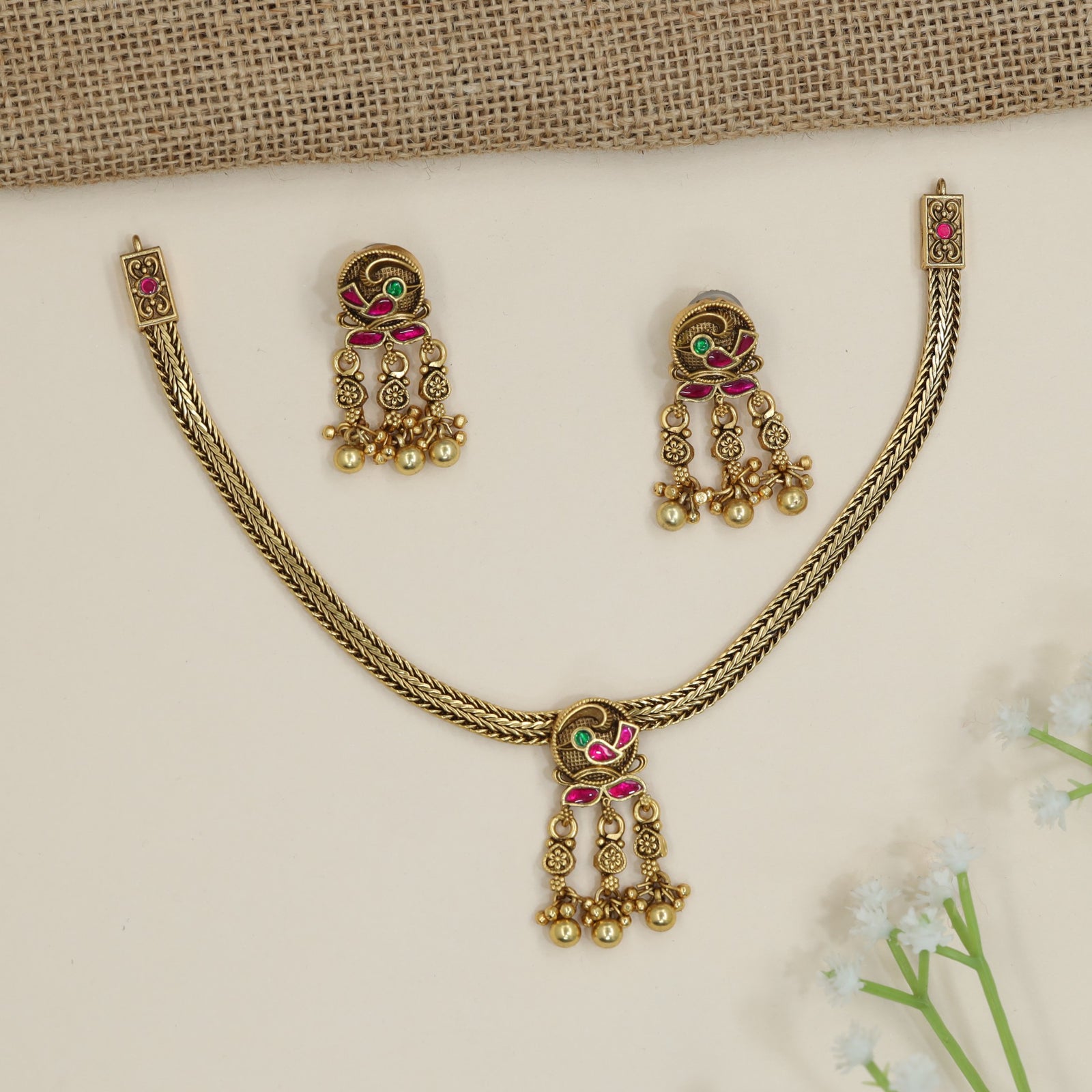Parrot motif necklace with braided chain silhouette and dangling accents