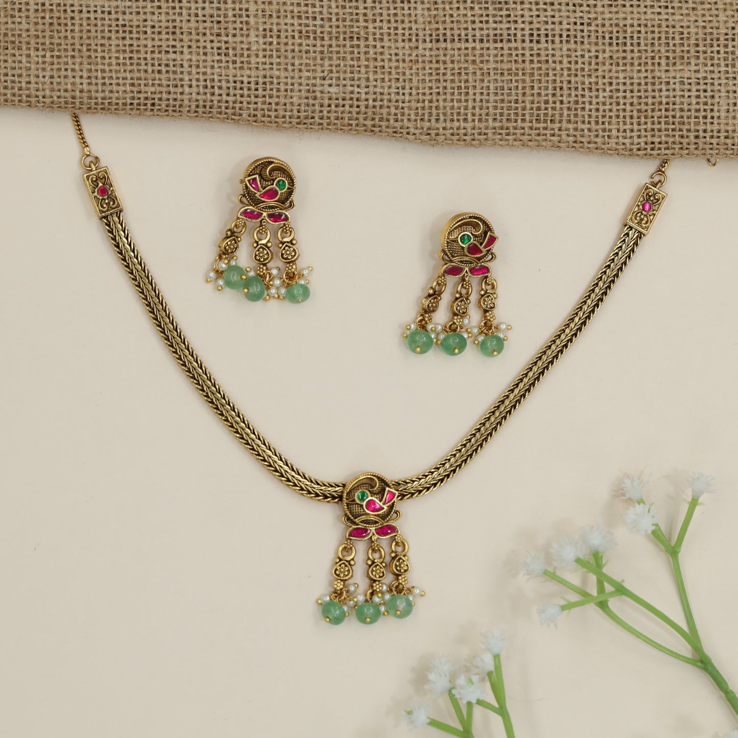 Parrot motif necklace with braided chain silhouette and dangling accents