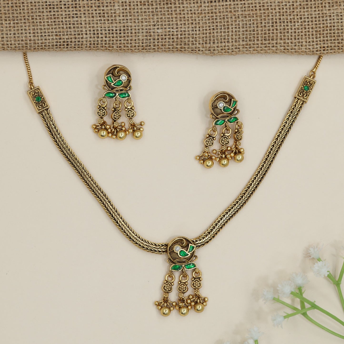 Parrot motif necklace with braided chain silhouette and dangling accents
