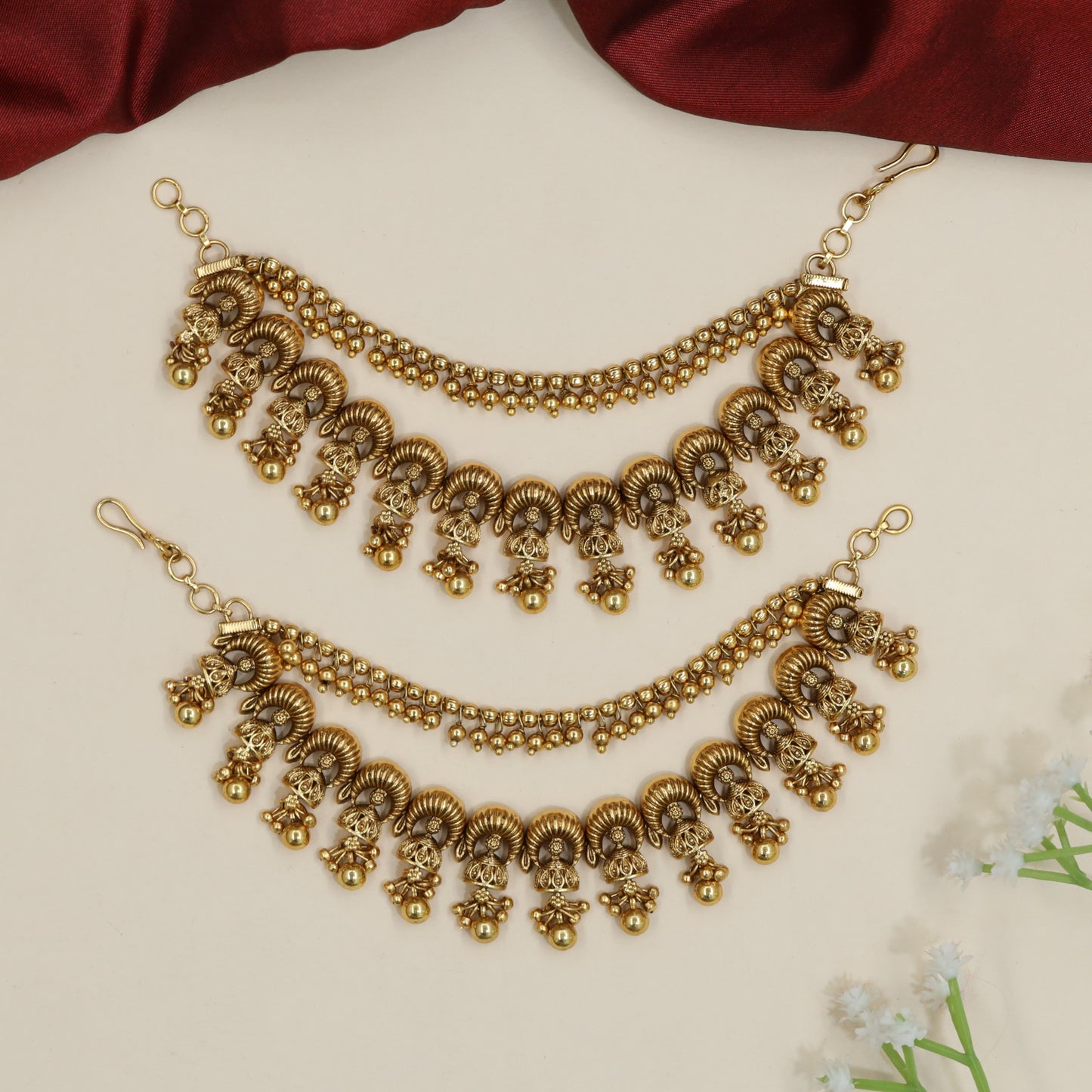 Curved horn motif Antique Mati with ornamental fringe accents