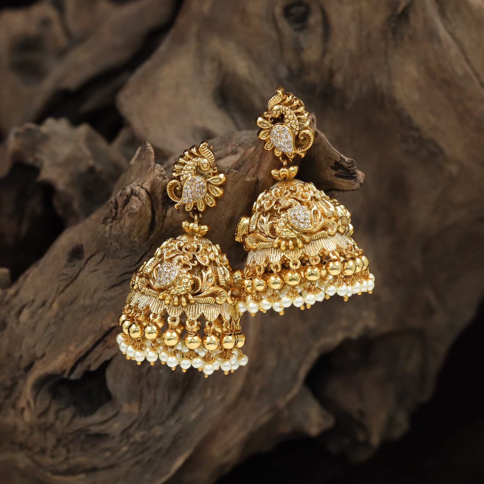 Grand peacock jhumka with intricate scrollwork and pearl border