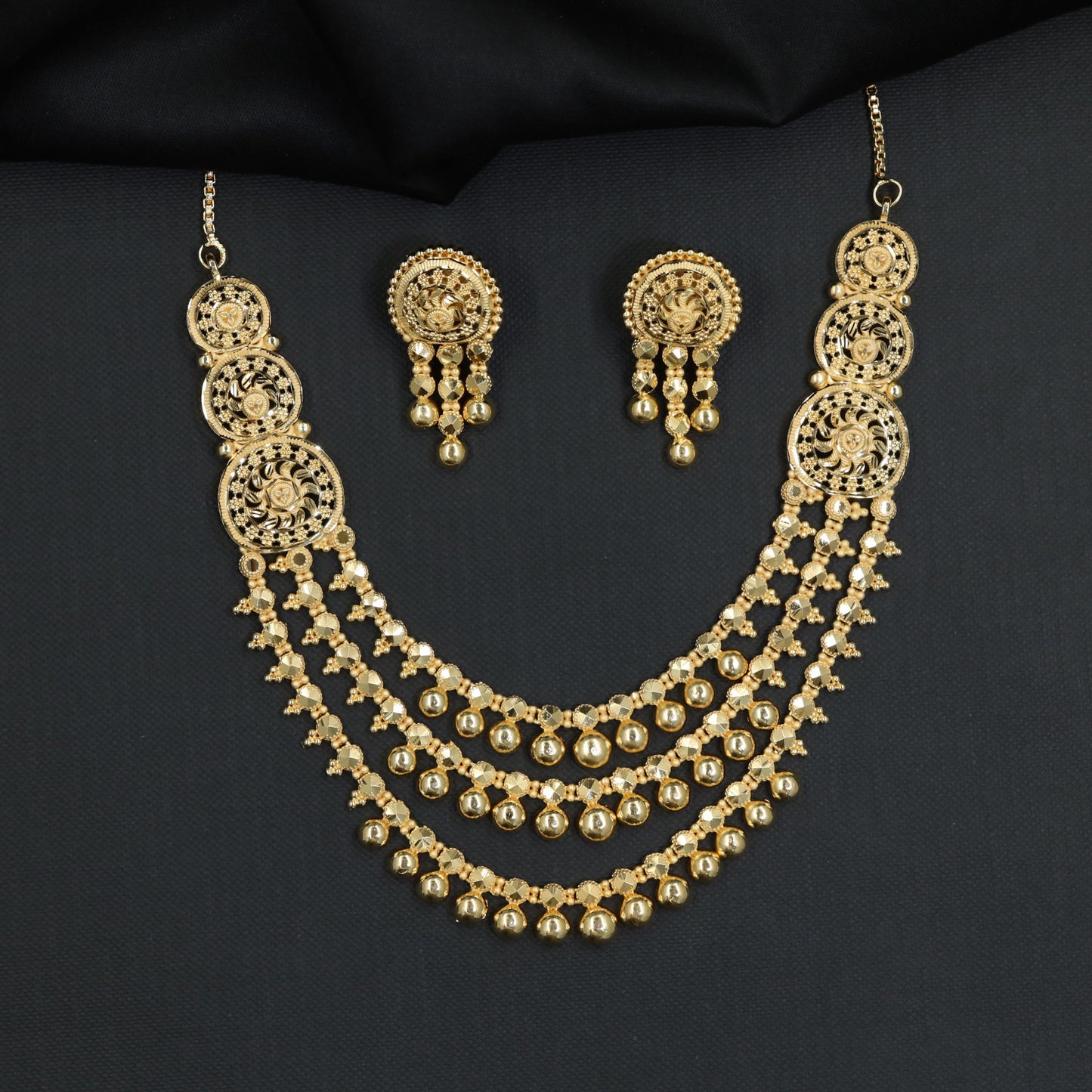 Forming Necklace with three-tier beaded strands and circular side plaques