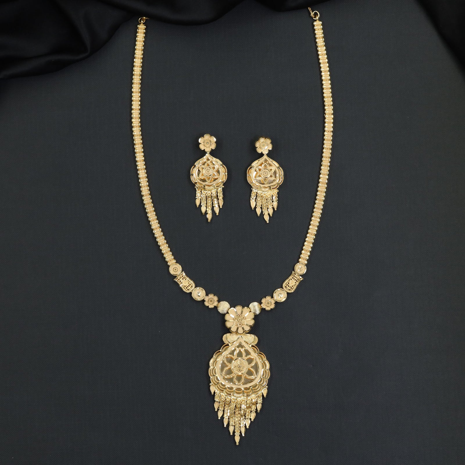 Forming Long Haara with floral filigree medallion and tassel drops