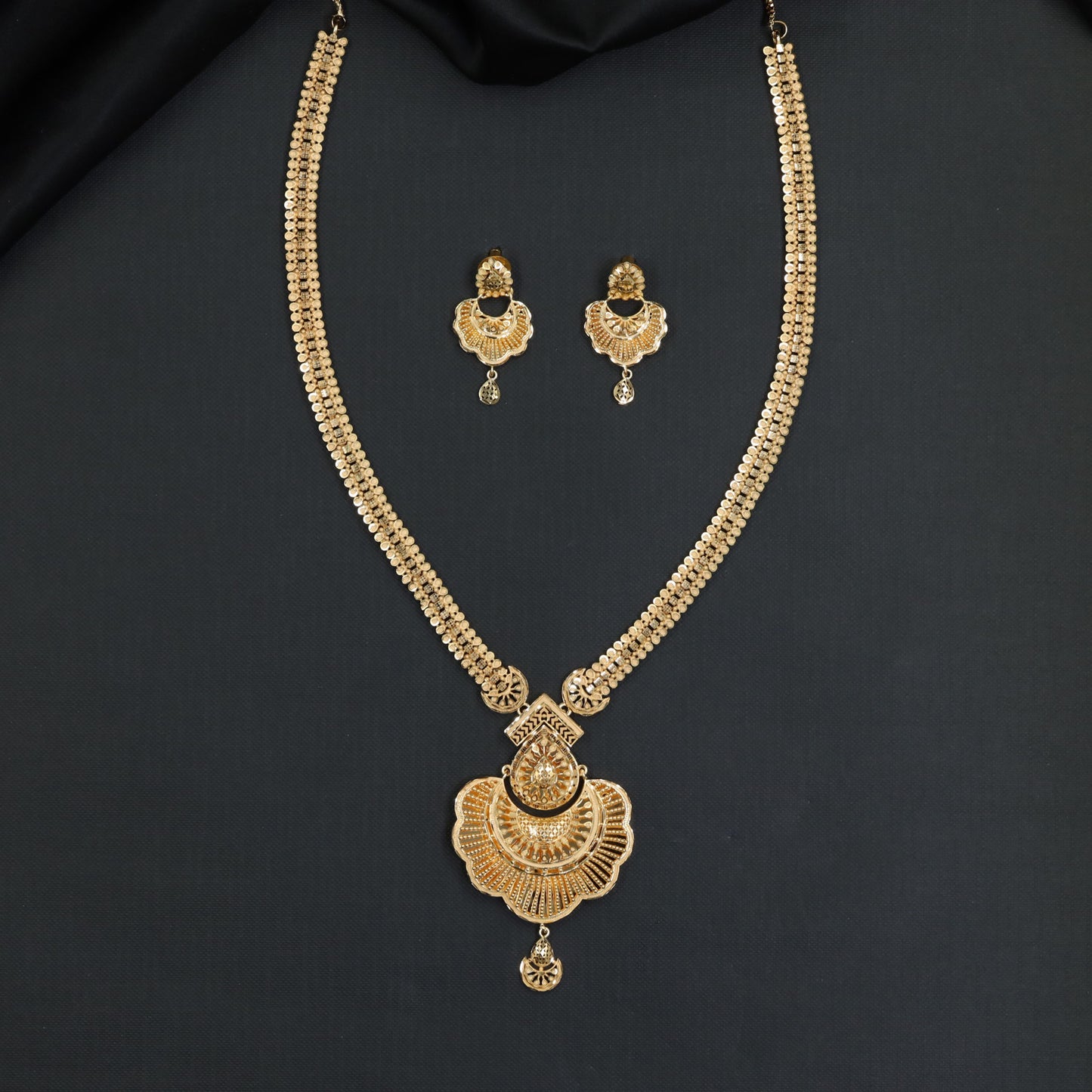 Opulent forming long haara with artistic fan‑pattern pendant