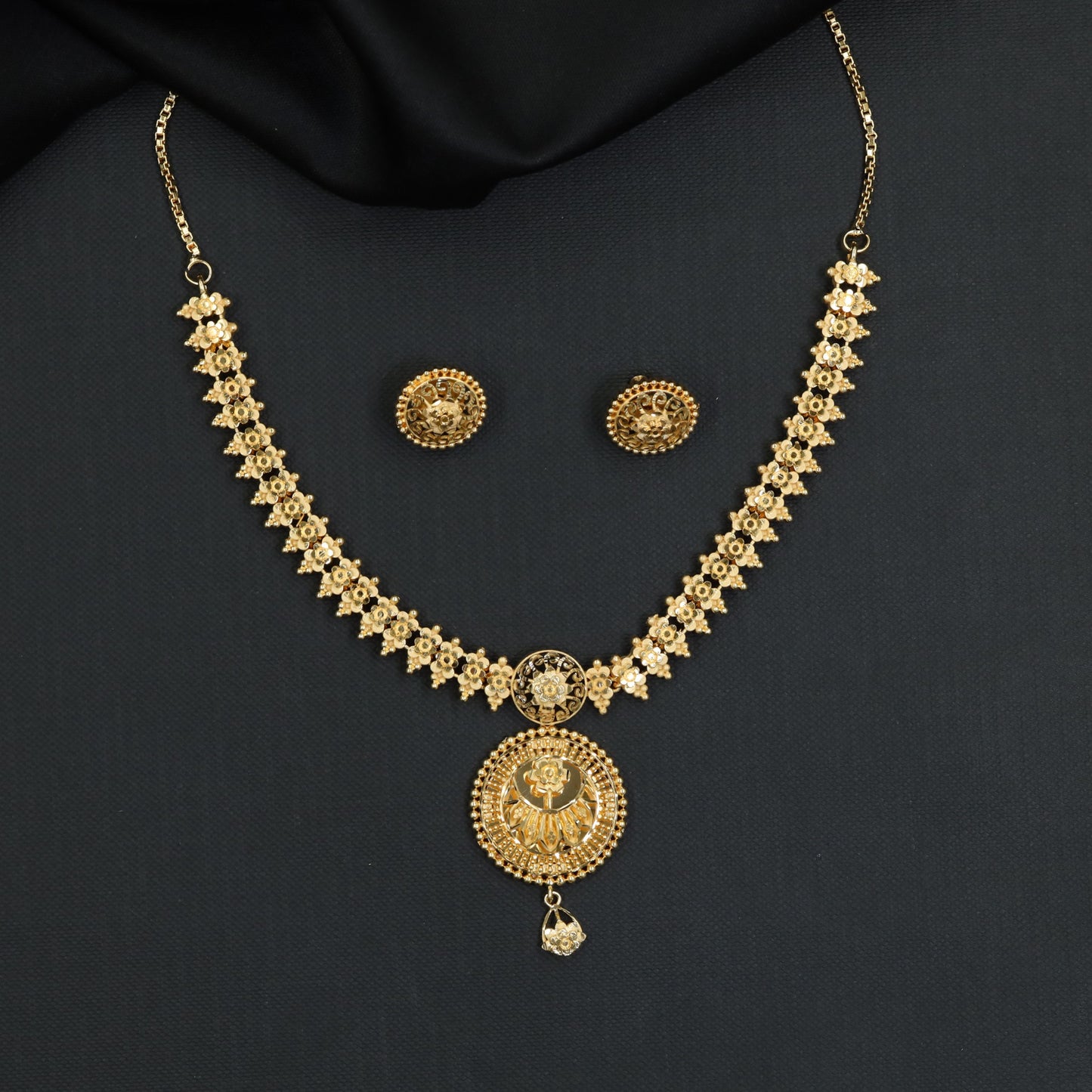 Continuous floral detailing with a sculpted round pendant in this Forming Necklace