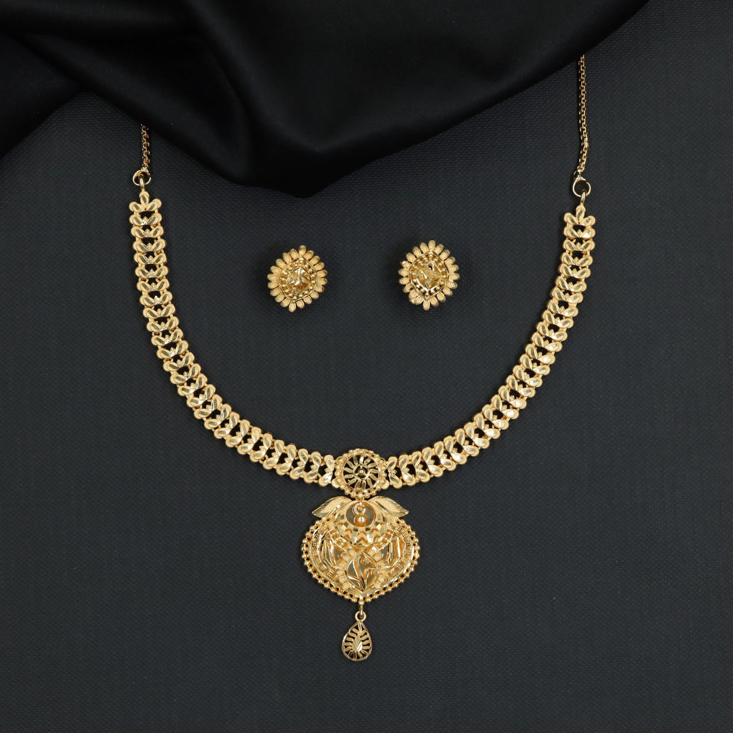 Sleek articulated chainwork accented by an ornate floral pendant Forming Necklace