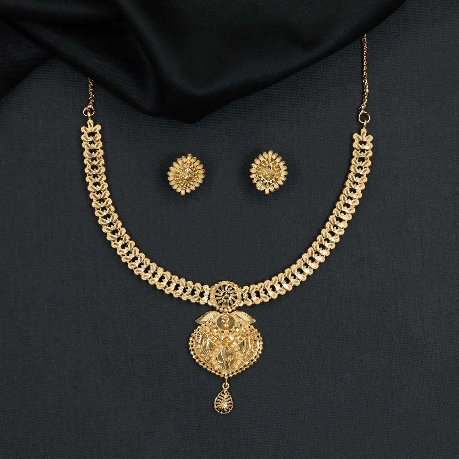 Sleek articulated chainwork accented by an ornate floral pendant Forming Necklace