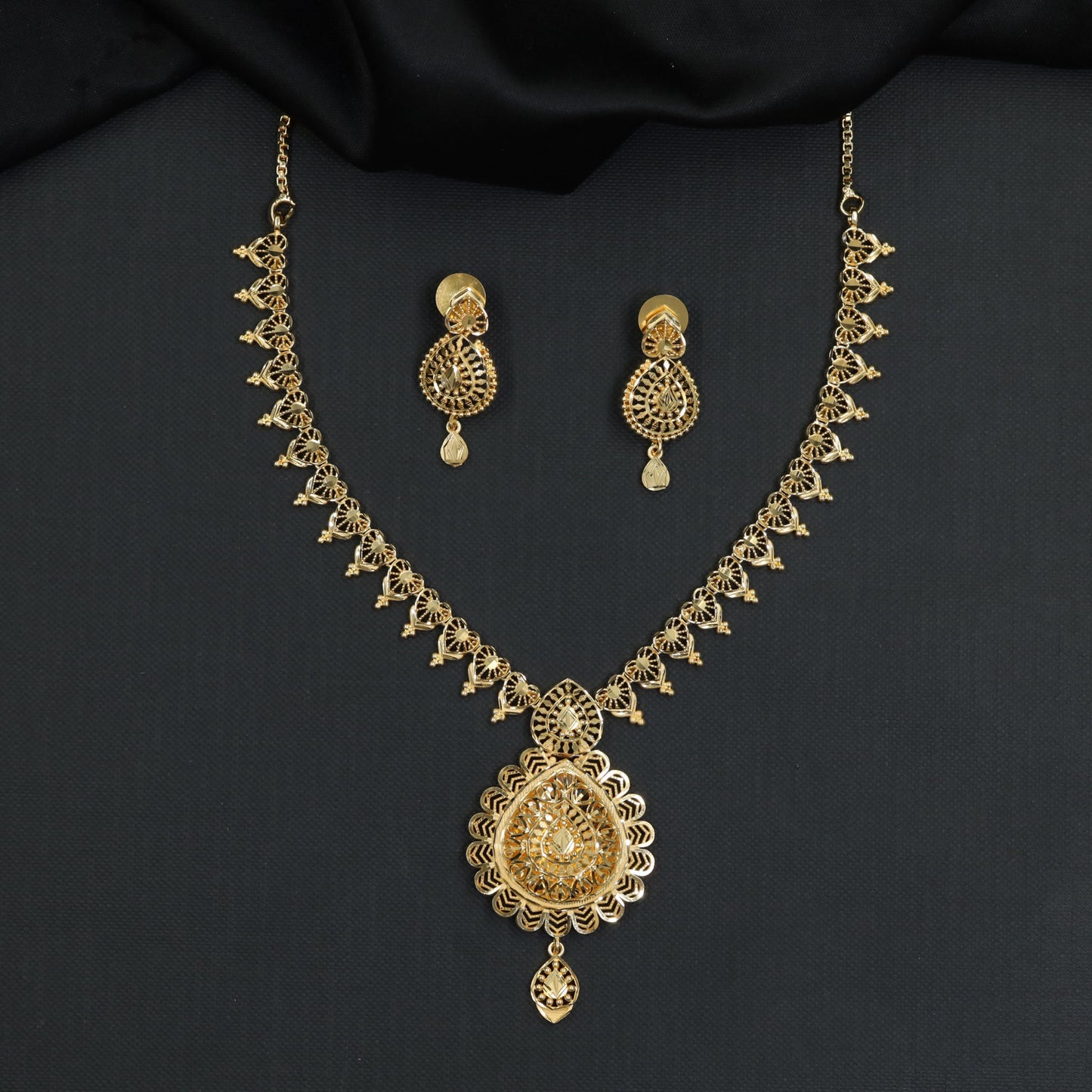 Continuous ornamental links flowing into a detailed centre pendant in a Forming Necklace