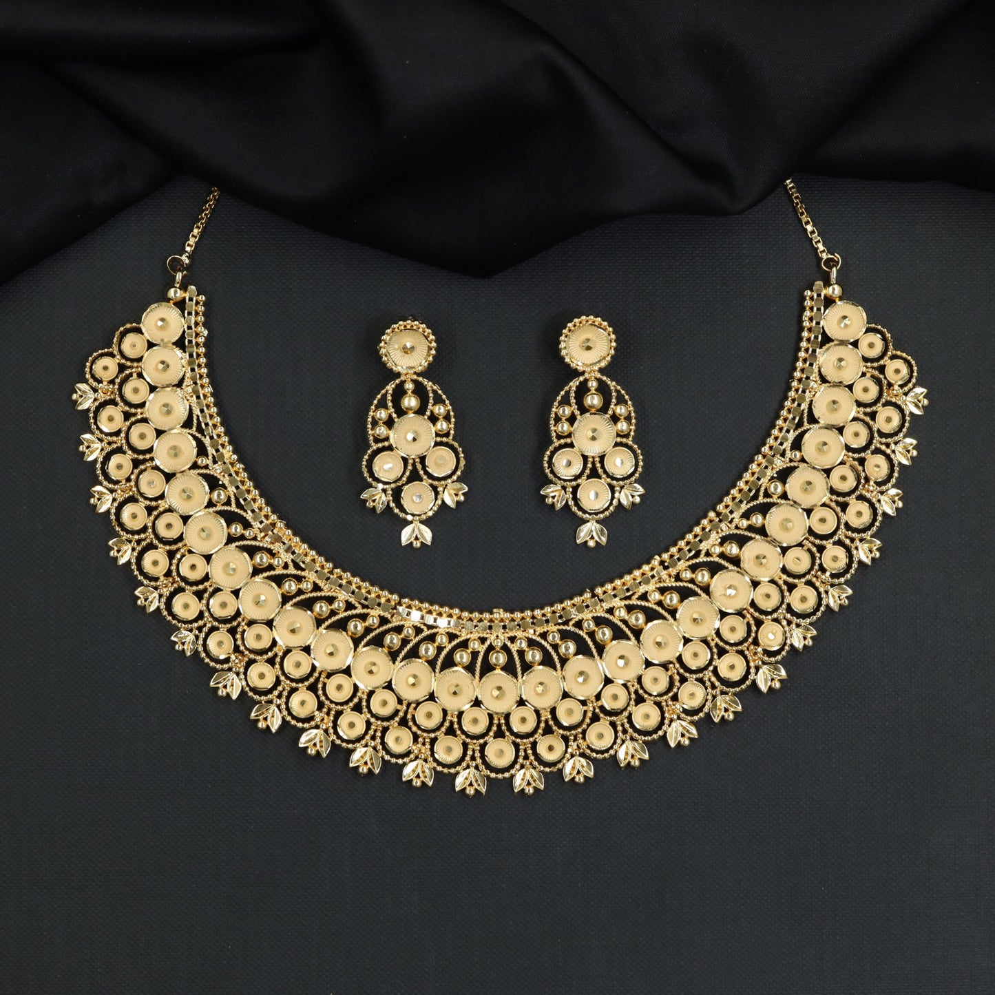 Radiant disc clusters sweep across an elegant openwork Forming Necklace